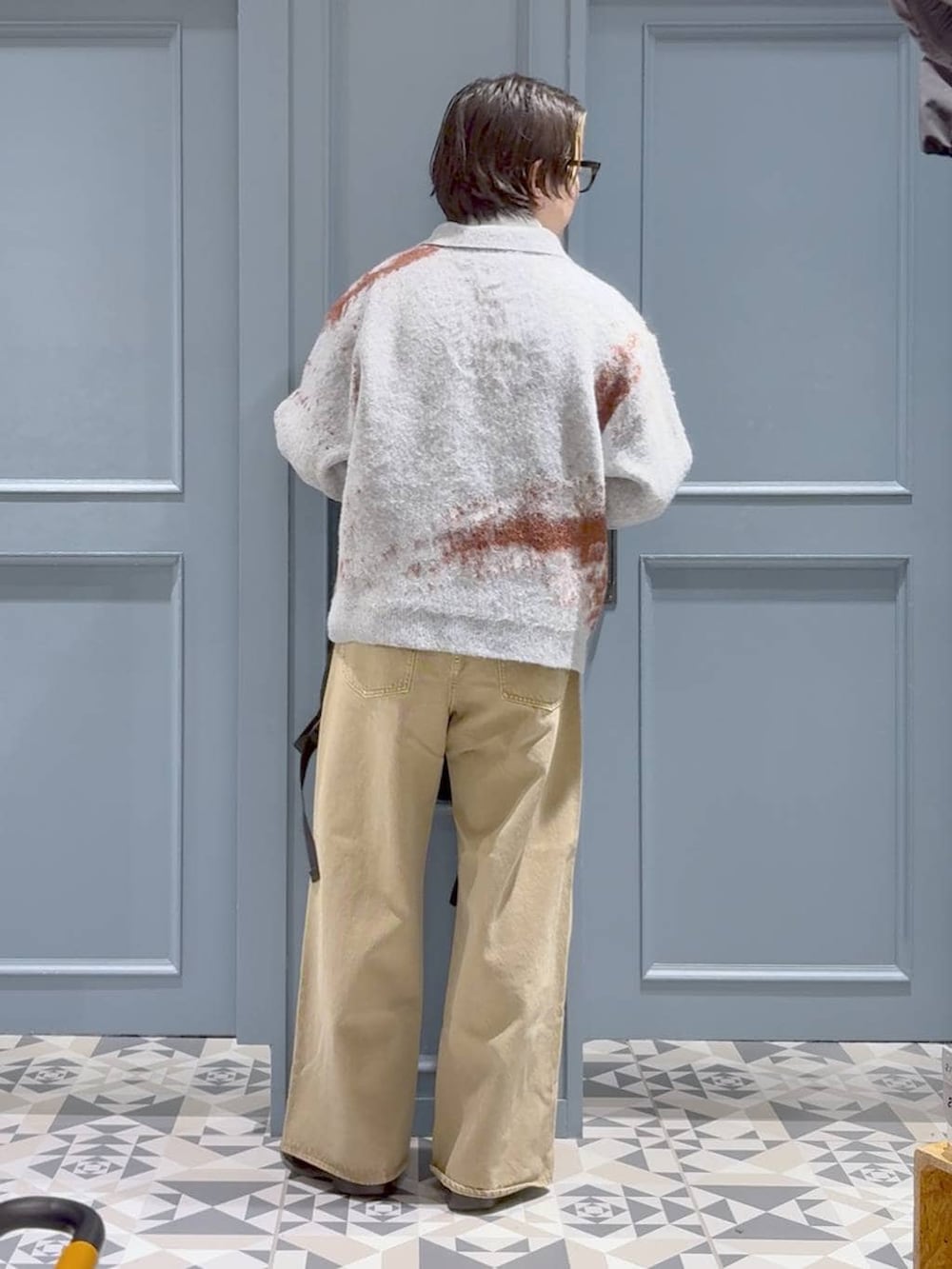 ベージュ系のデニムパンツ、ブラック系のバックパック/リュック、ホワイト系のTシャツ/カットソーを着用したメンズの冬コーディネートの3枚目の写真