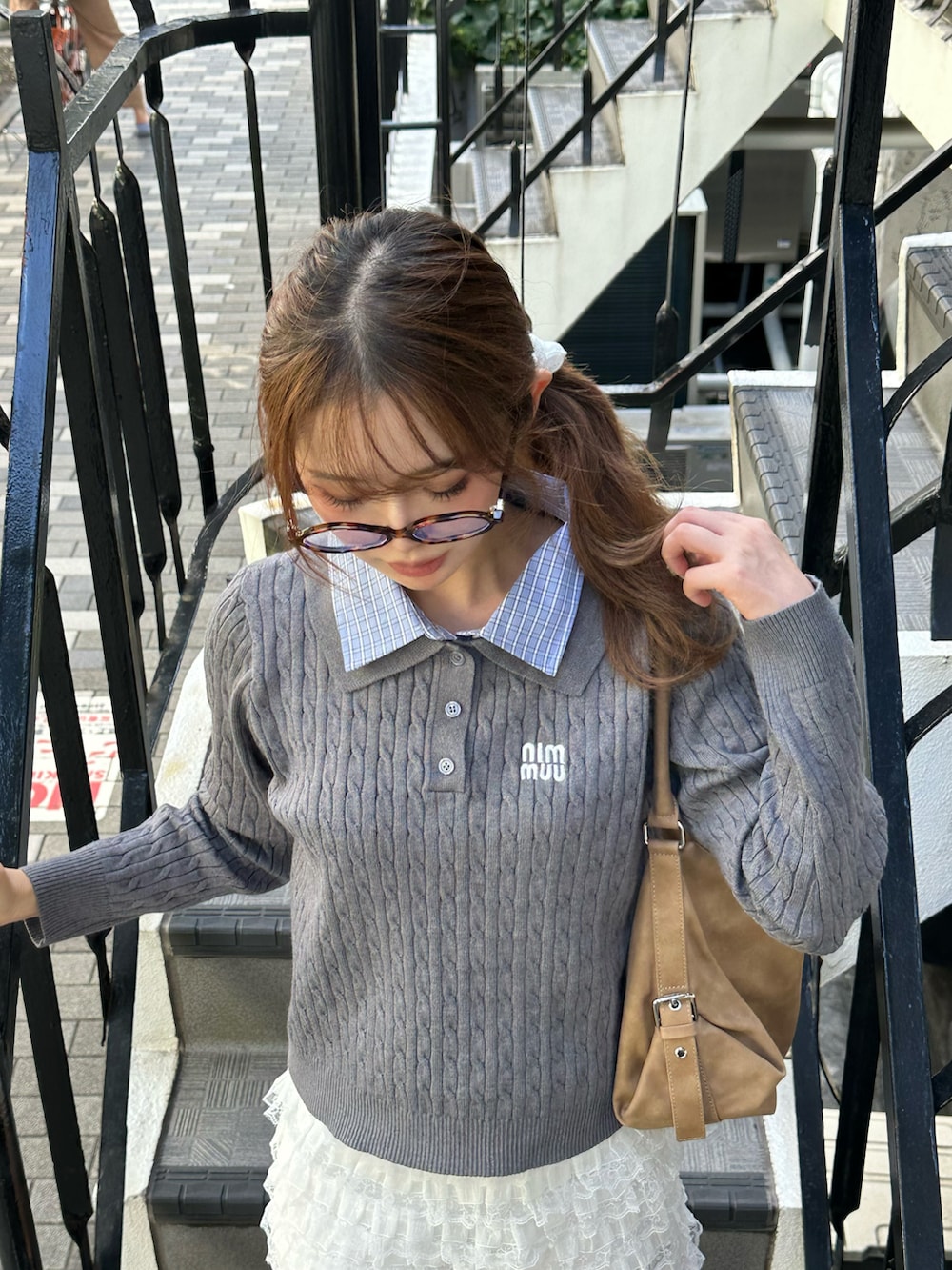 グレー系のニット/セーター、ホワイト系のスカート、ブラック系のパンプスを着用したレディースの秋コーディネートの2枚目の写真