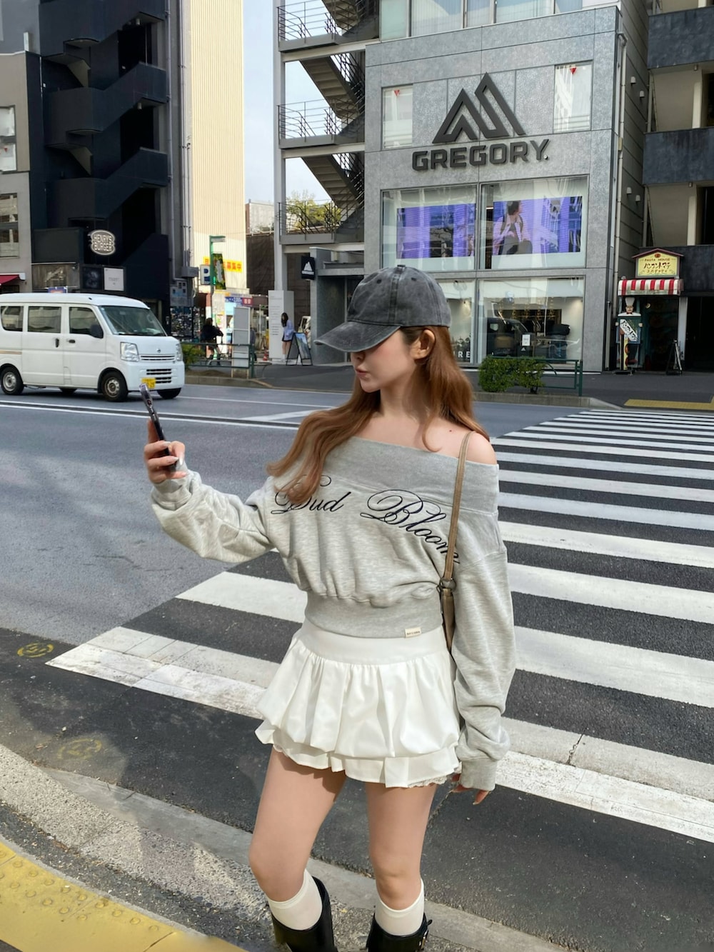 グレー系のスウェット、ホワイト系のスカート、ブラック系のブーツを着用したレディースの冬コーディネートの2枚目の写真