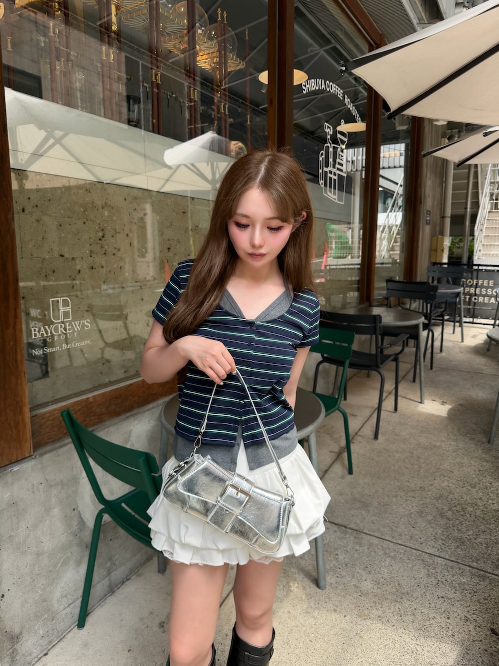 ホワイト系のスカート、ブルー系のトップス、ブラック系のブーツを着用したレディースの夏コーディネートの2枚目の写真