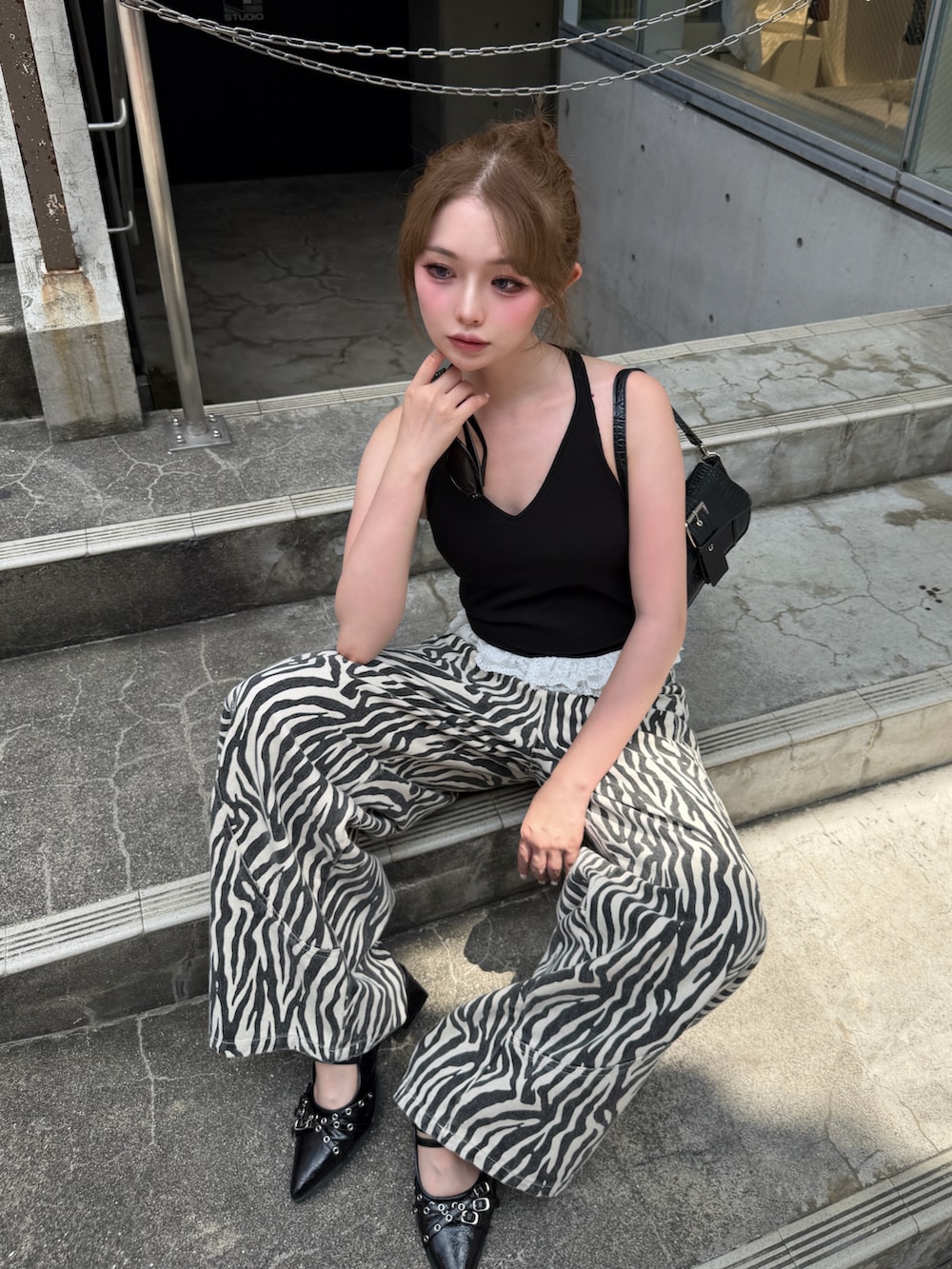ブラック系のタンクトップ、ホワイト系のデニムパンツ、ブラック系のサンダルを着用したレディースの夏コーディネートの2枚目の写真