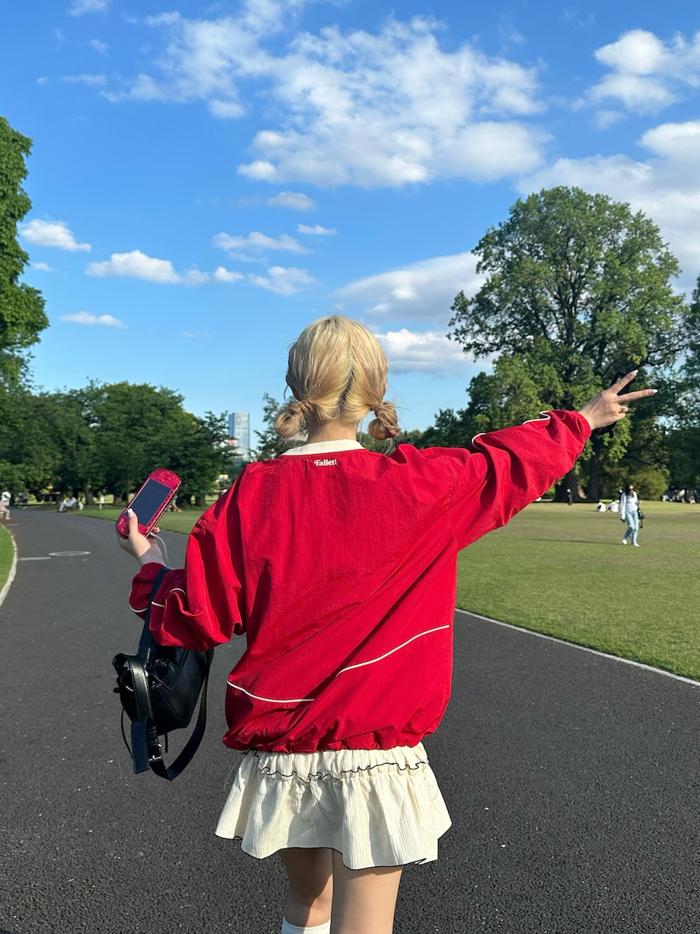 レッド系のTシャツ/カットソー、ホワイト系のワンピース、レッド系のスニーカーを着用したレディースの夏コーディネートの2枚目の写真