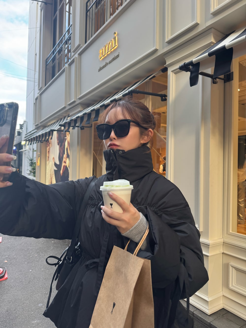 ブラック系のダウンジャケット/コート、グレー系のワンピースを着用したレディースの秋コーディネートの2枚目の写真