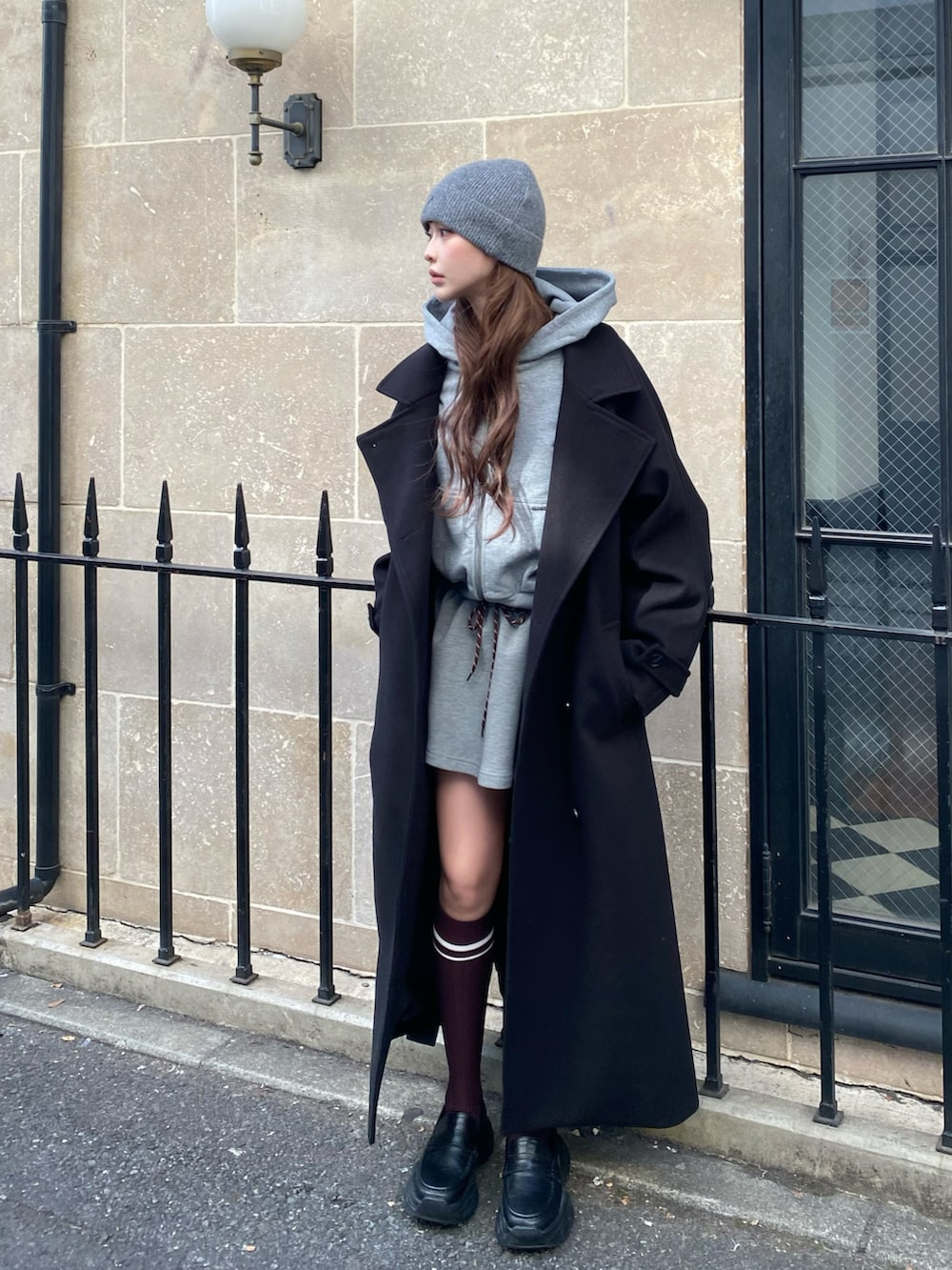 ブラック系のその他アウター、グレー系のパーカー、グレー系のスカートを着用したレディースの秋コーディネートの2枚目の写真