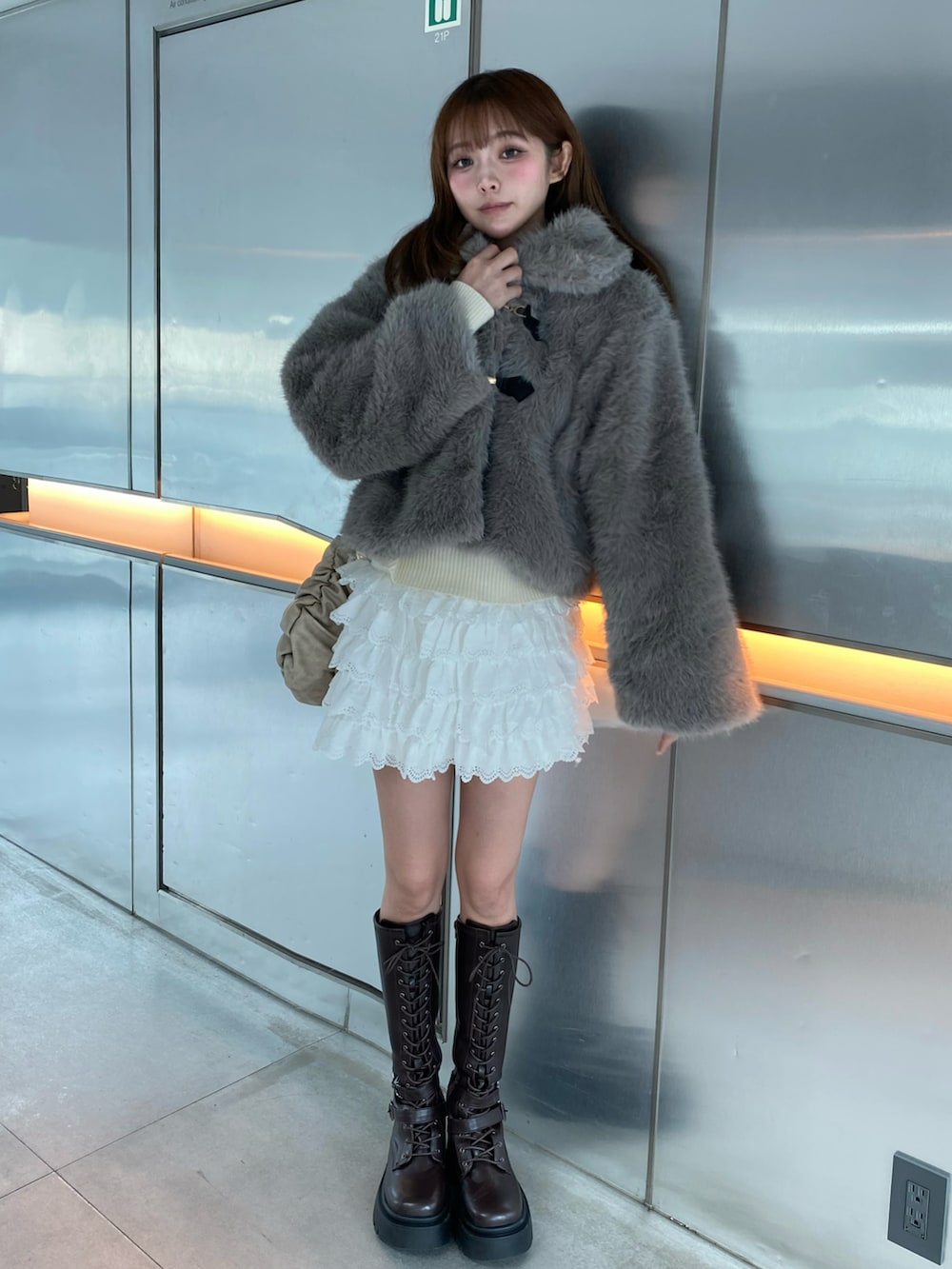 グレー系のジャケット/アウター、ホワイト系のスカート、ブラウン系のブーツを着用したレディースの秋コーディネートの2枚目の写真