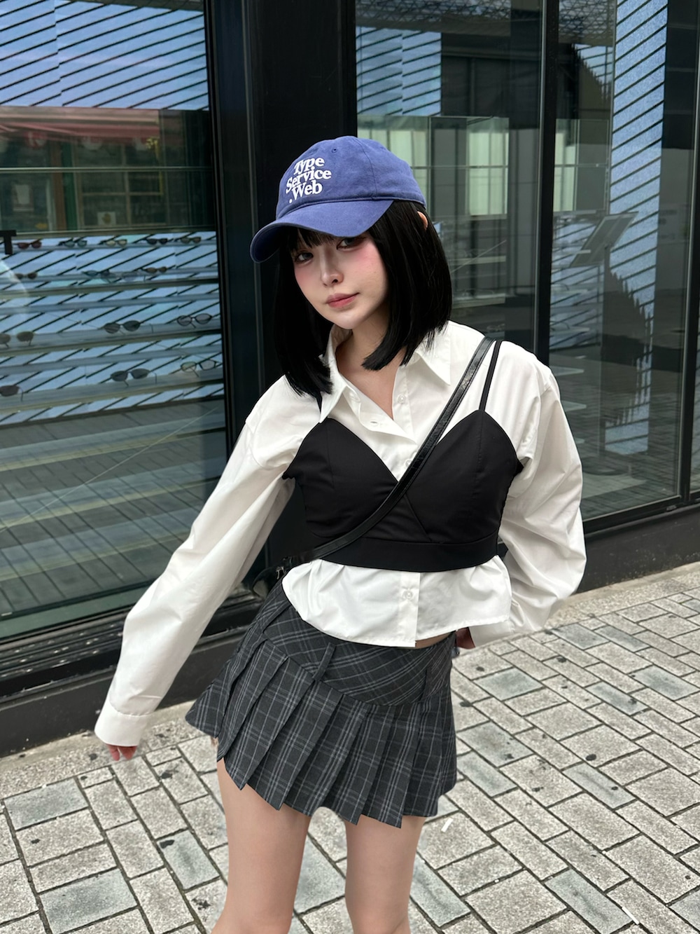 ホワイト系のスニーカー、グレー系のスカート、ホワイト系のシャツ/ブラウスを着用したレディースの夏コーディネートの2枚目の写真