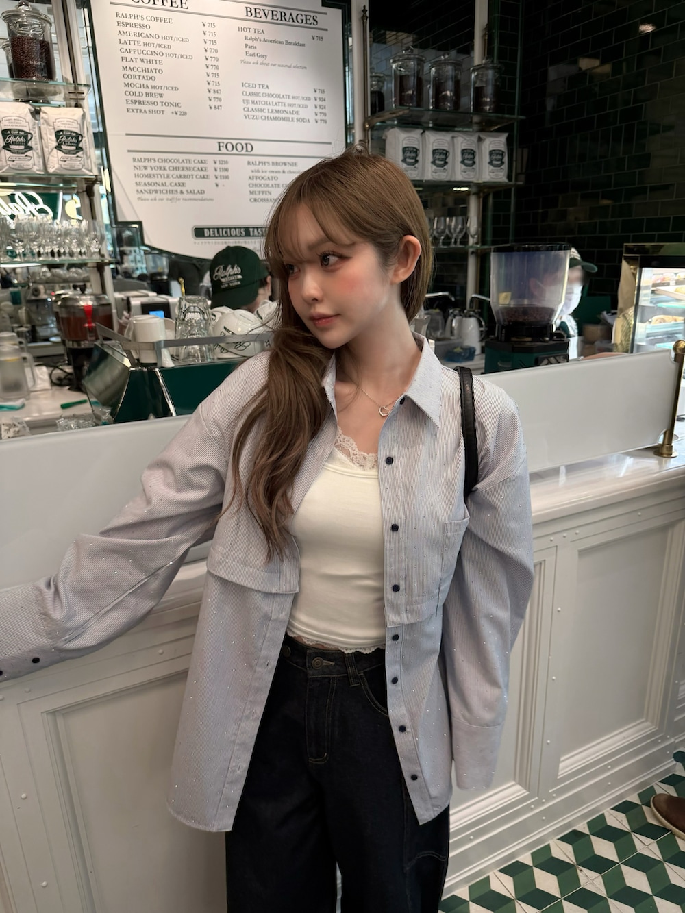 ブルー系のデニムパンツ、ブルー系のシャツ/ブラウス、ブラック系のショルダーバッグを着用したレディースの春コーディネートの2枚目の写真