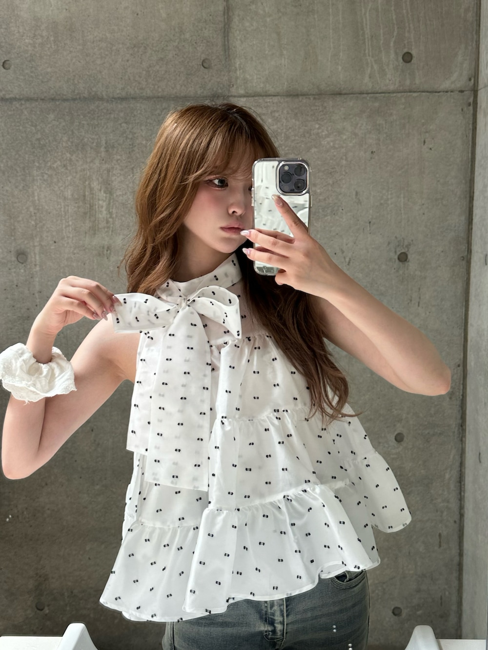 ブルー系のデニムパンツ、ベージュ系のバッグ、ホワイト系のスニーカーを着用したレディースの春コーディネートの3枚目の写真