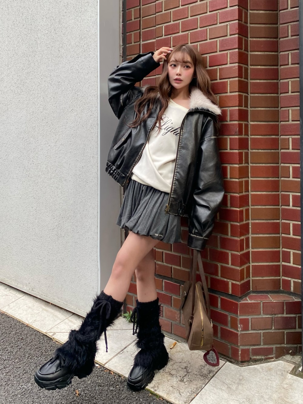 ブラック系のブルゾン、ベージュ系のスウェット、ブラウン系のトートバッグを着用したレディースの秋コーディネートの3枚目の写真