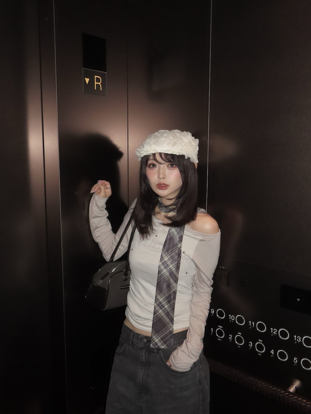 ベージュ系のTシャツ/カットソー、ブラック系のデニムパンツ、ブラック系のスニーカーを着用したレディースの春コーディネートの2枚目の写真