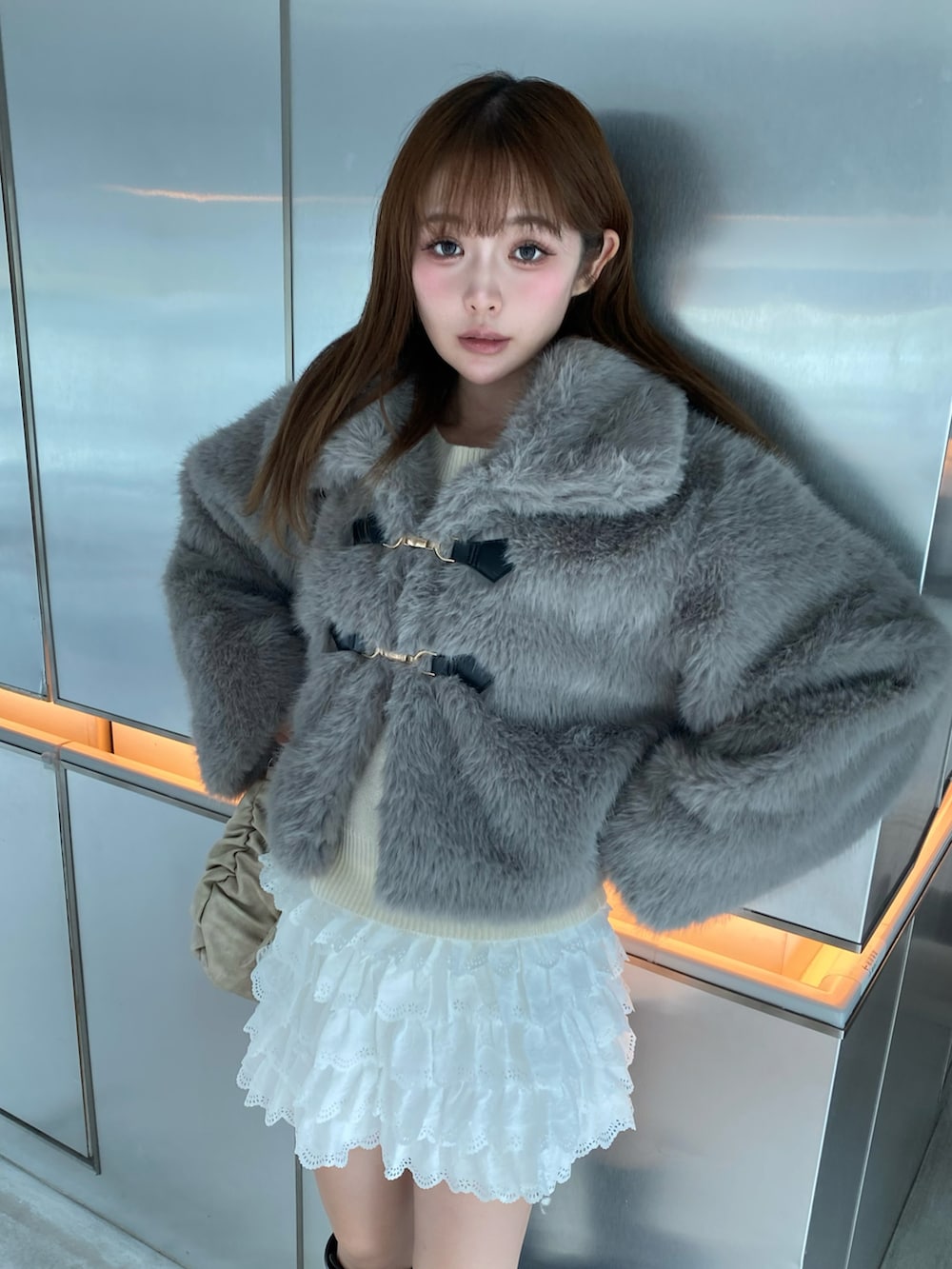 グレー系のジャケット/アウター、ホワイト系のスカート、ブラウン系のブーツを着用したレディースの秋コーディネートの3枚目の写真