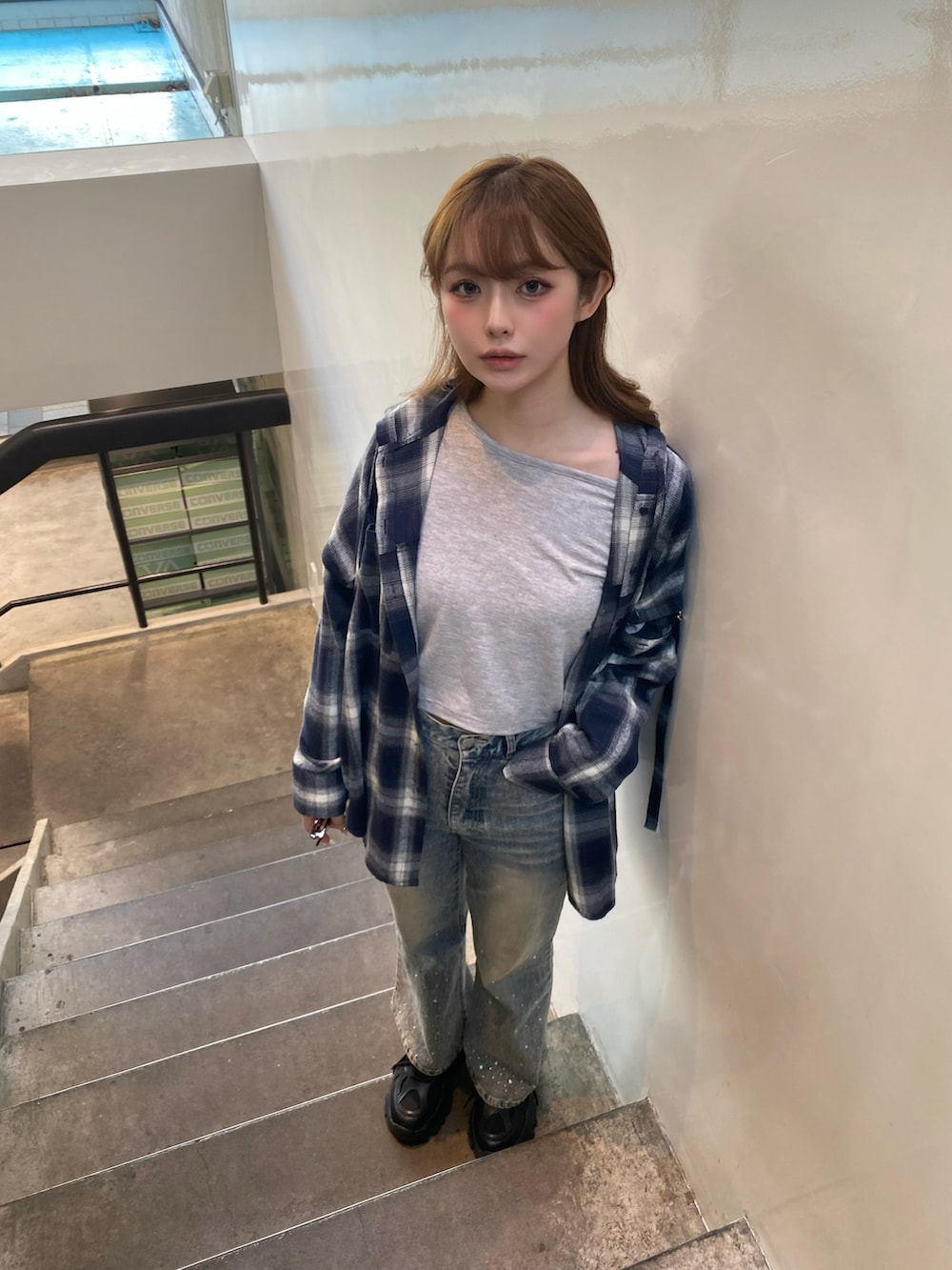 ブルー系のデニムパンツ、ブラック系のスニーカー、グレー系のTシャツ/カットソーを着用したレディースの春コーディネートの3枚目の写真