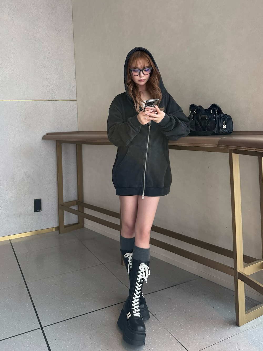 ホワイト系のTシャツ/カットソー、グレー系のその他パンツ、ブラック系のブーツを着用したレディースの冬コーディネートの3枚目の写真