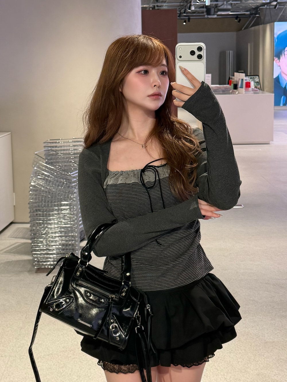 ブラック系のTシャツ/カットソー、ブラック系のスカート、ブラック系のショルダーバッグを着用したレディースの春コーディネートの2枚目の写真