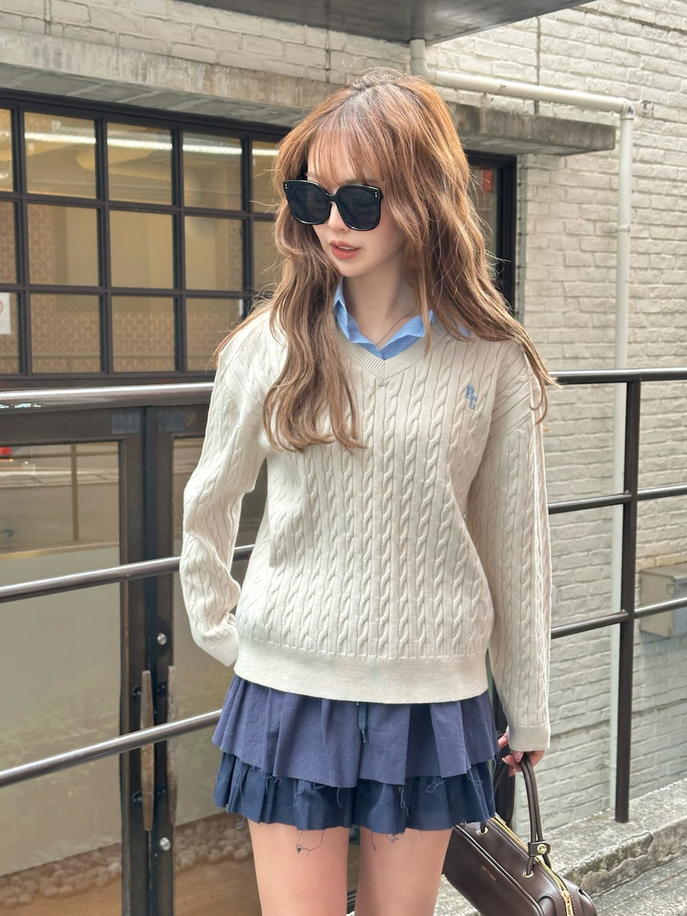 ホワイト系のニット/セーター、ブラウン系のその他シューズ、ブラウン系のボストンバッグを着用したレディースの冬コーディネートの3枚目の写真