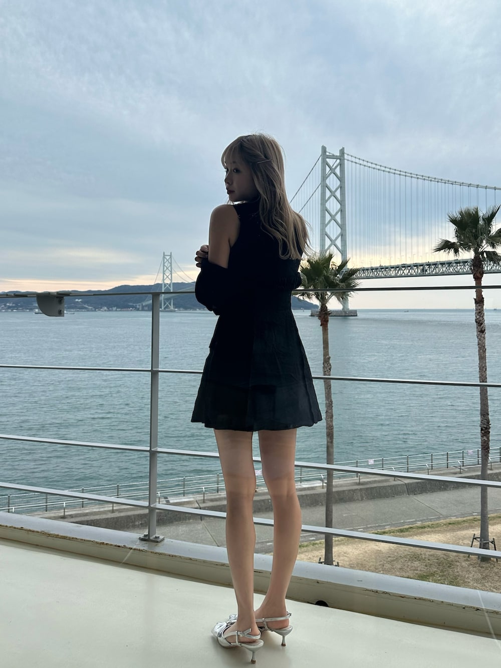 ブラック系のワンピース、シルバー系のパンプスを着用したレディースの夏コーディネートの2枚目の写真