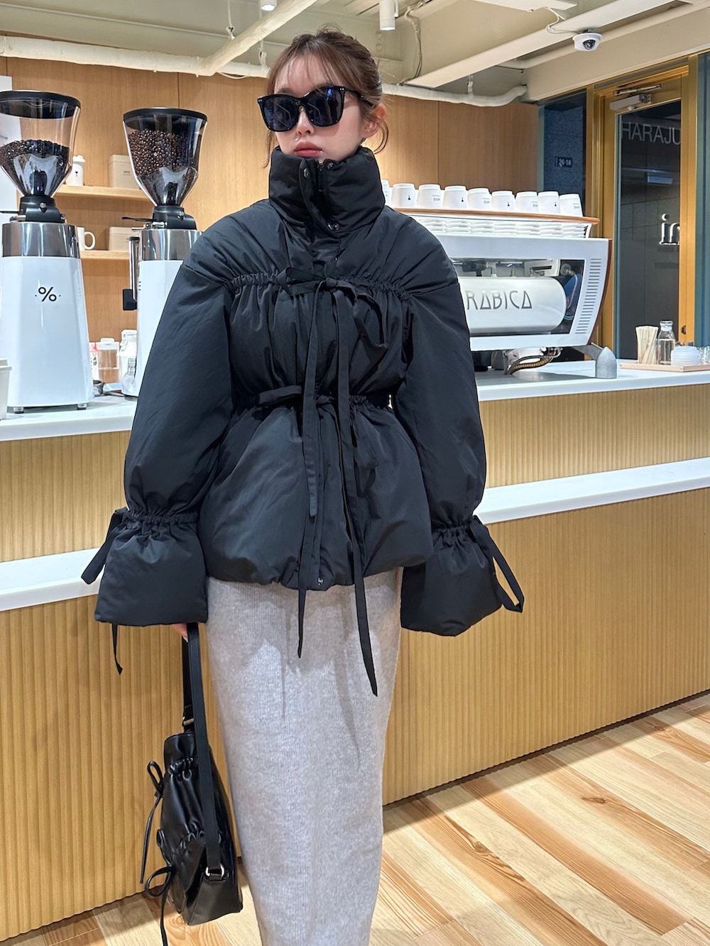 ブラック系のダウンジャケット/コート、グレー系のワンピースを着用したレディースの秋コーディネートの3枚目の写真