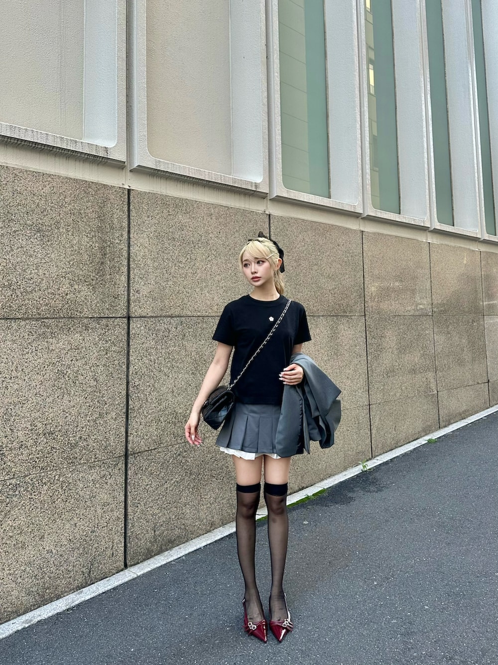 グレー系のスカート、レッド系のシューズ、ブラック系のTシャツ/カットソーを着用したレディースの夏コーディネートの3枚目の写真