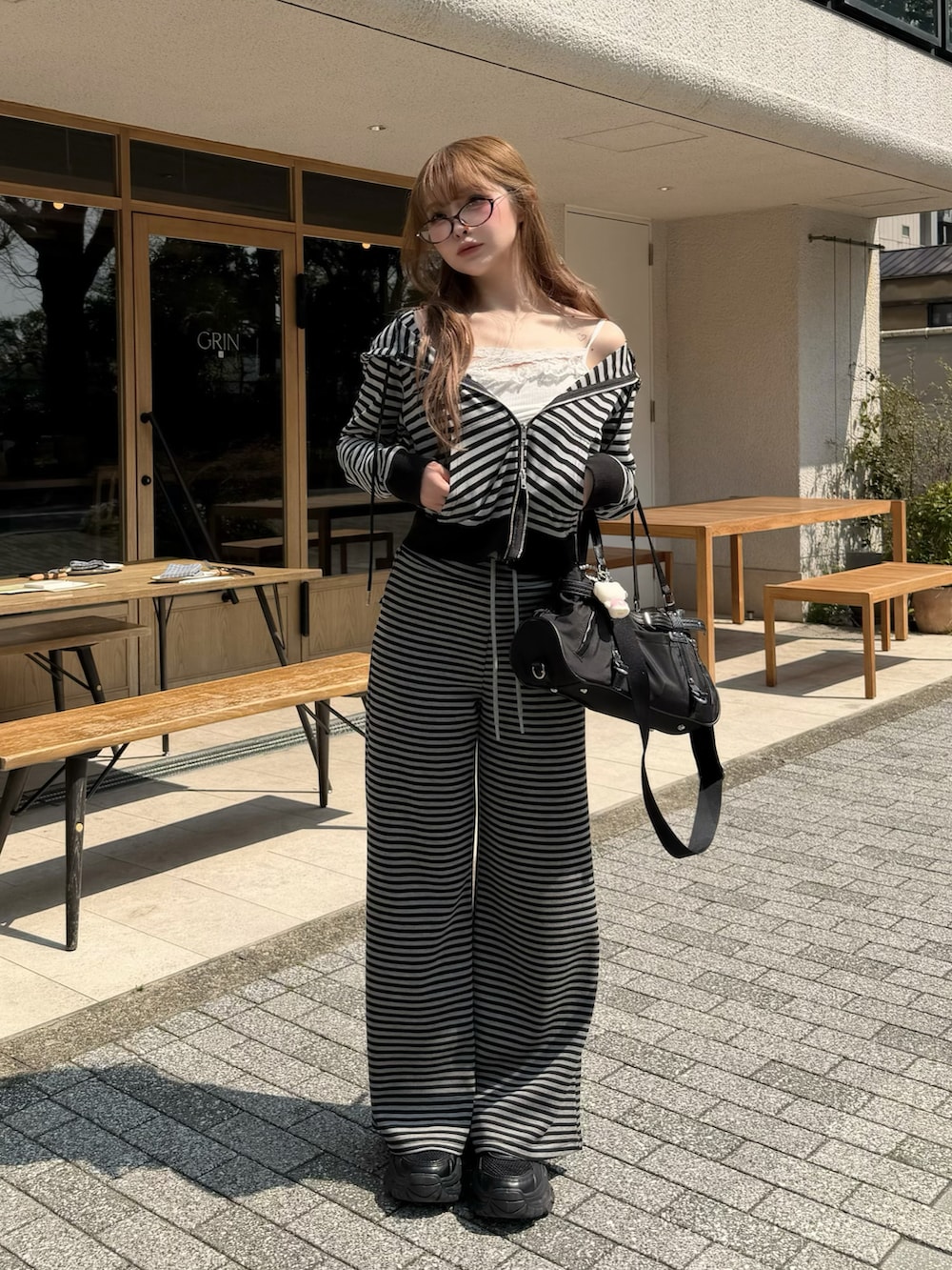 グレー系のその他パンツ、グレー系のパーカー、ブラック系のスニーカーを着用したレディースの春コーディネートの2枚目の写真