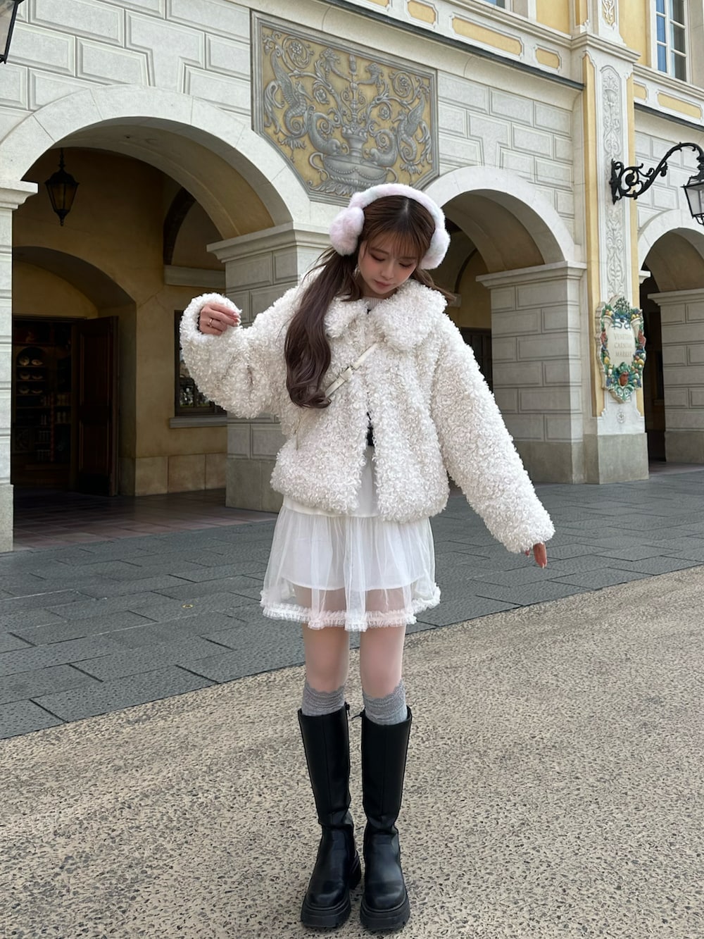 ホワイト系のジャケット/アウター、ホワイト系のスカート、ブラック系のブーツを着用したレディースの冬コーディネートの2枚目の写真