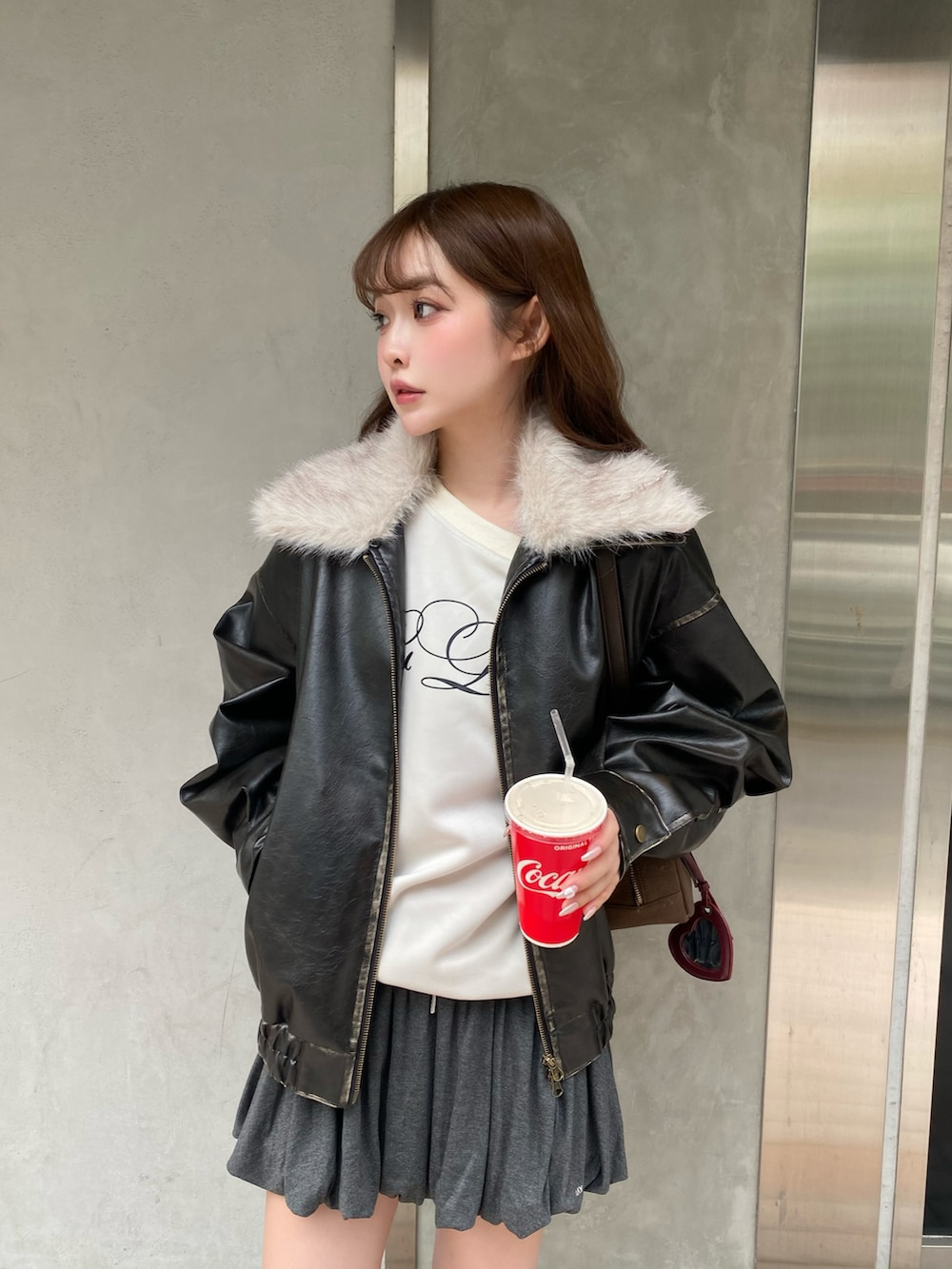 ブラック系のブルゾン、ベージュ系のスウェット、ブラウン系のトートバッグを着用したレディースの秋コーディネートの5枚目の写真