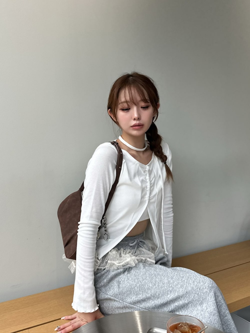 グレー系のスウェットパンツ、ホワイト系のトップス、ブラウン系のバッグを着用したレディースの夏コーディネートの2枚目の写真