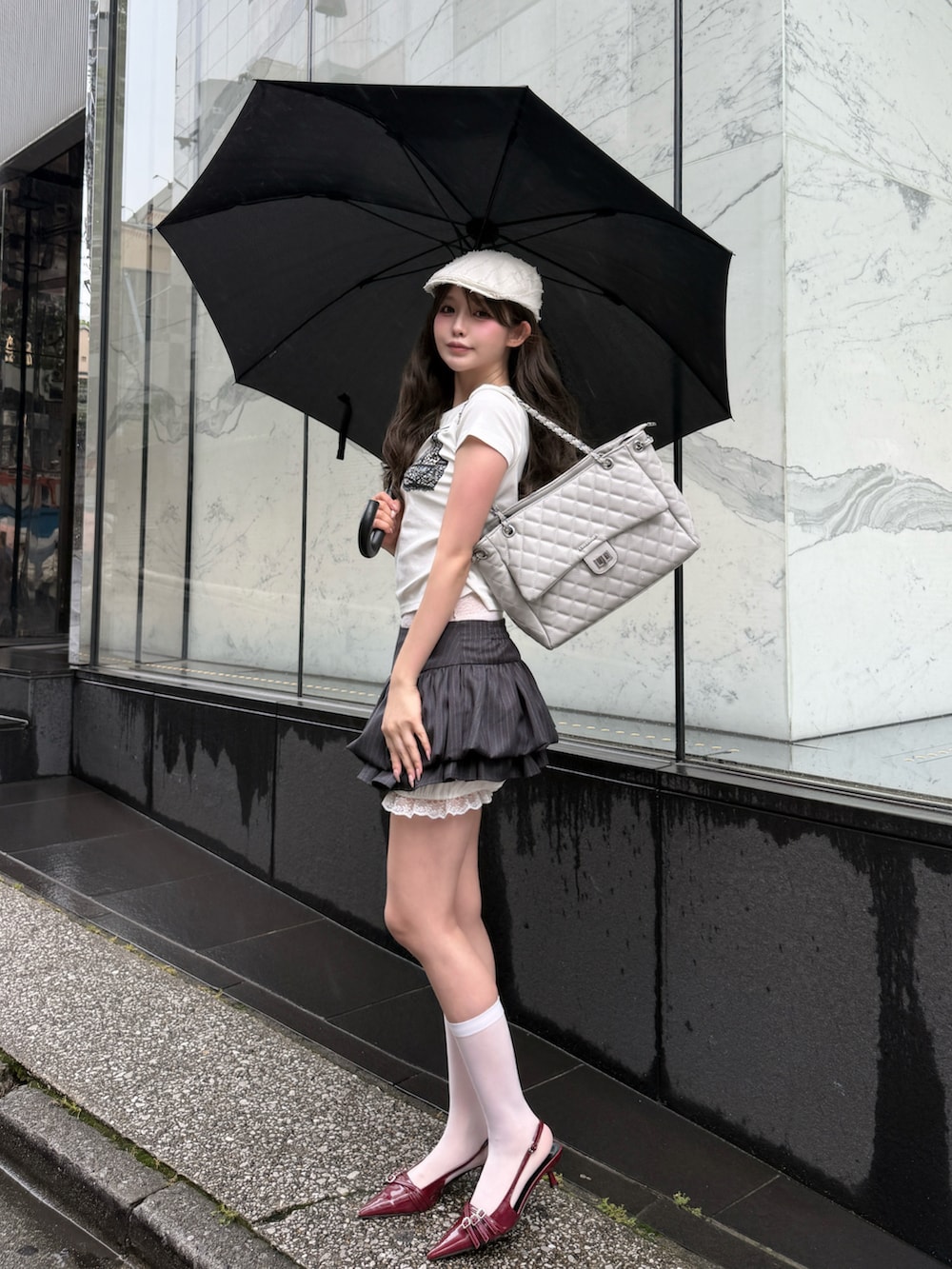 ホワイト系のTシャツ/カットソー、グレー系のスカート、グレー系のショルダーバッグを着用したレディースの夏コーディネートの2枚目の写真