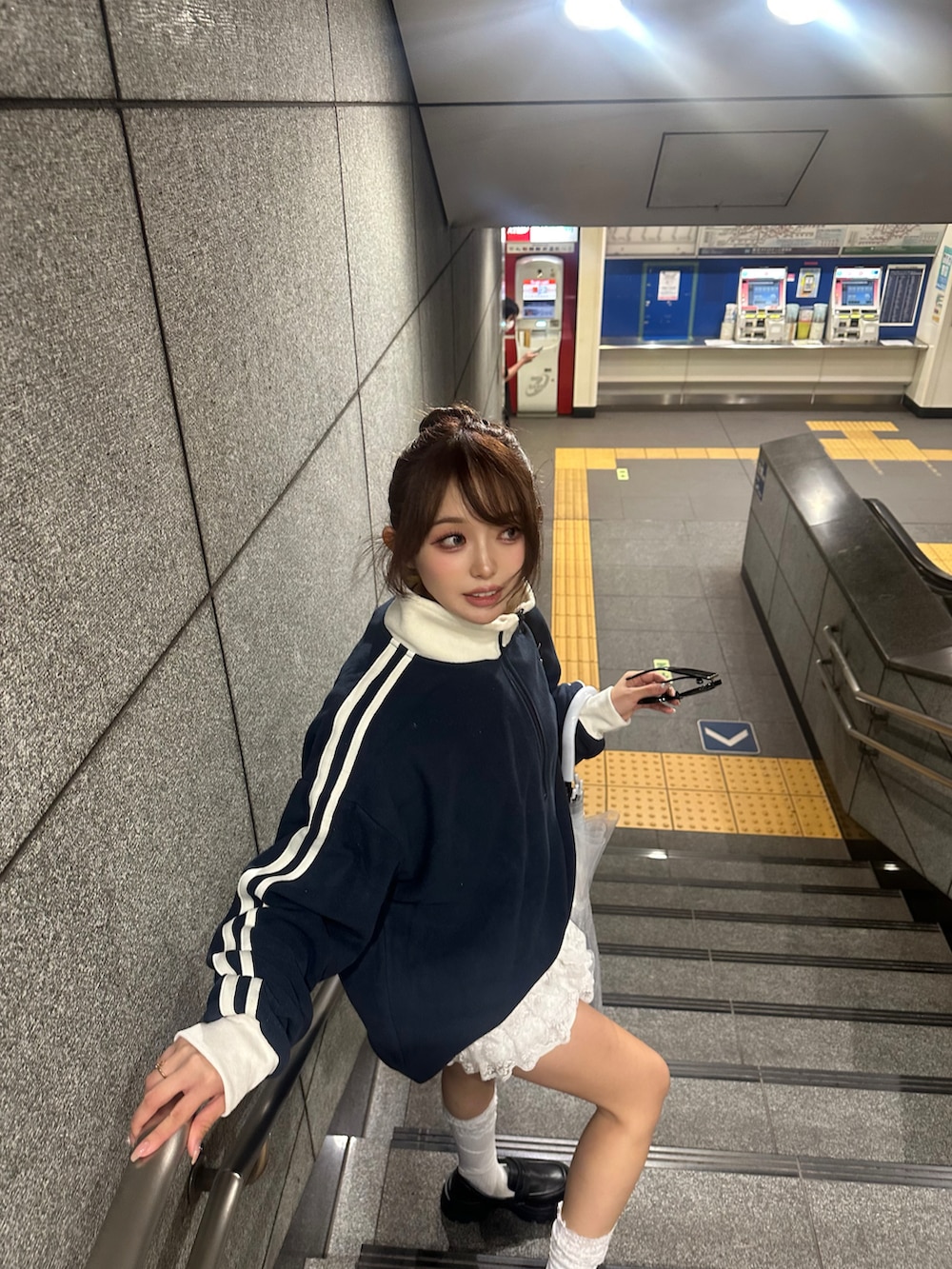 ブルー系のスウェット、ホワイト系のパンツ、ブラック系のローファーを着用したレディースの秋コーディネートの2枚目の写真