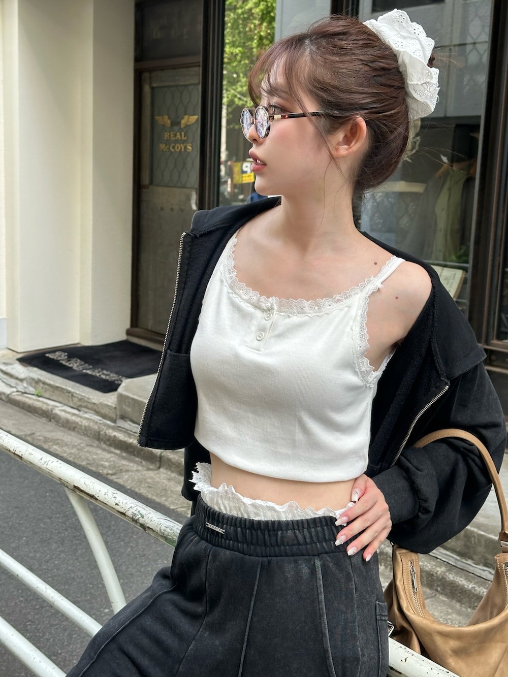 ブラック系のスウェットパンツ、ブラック系のパーカー、ブラウン系のバッグを着用したレディースの春コーディネートの3枚目の写真