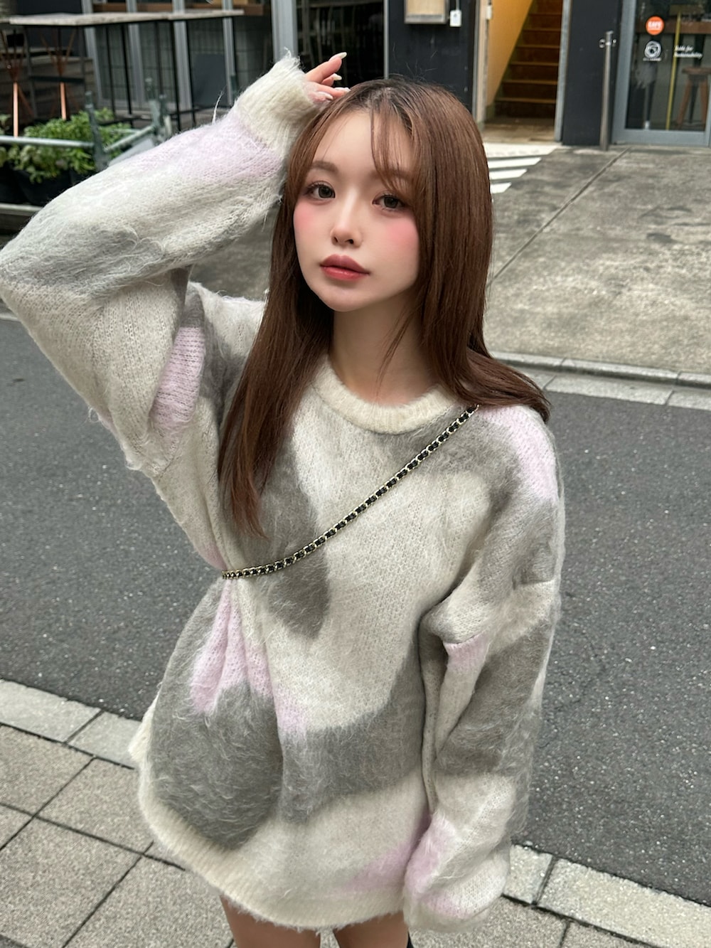 グレー系のニット/セーター、ブラック系のブーツ、ブラック系のショルダーバッグを着用したレディースの秋コーディネートの2枚目の写真