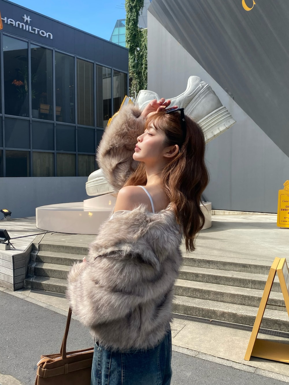 ホワイト系のブルゾン、ブラック系のショルダーバッグ、ブルー系のデニムパンツを着用したレディースの秋コーディネートの3枚目の写真