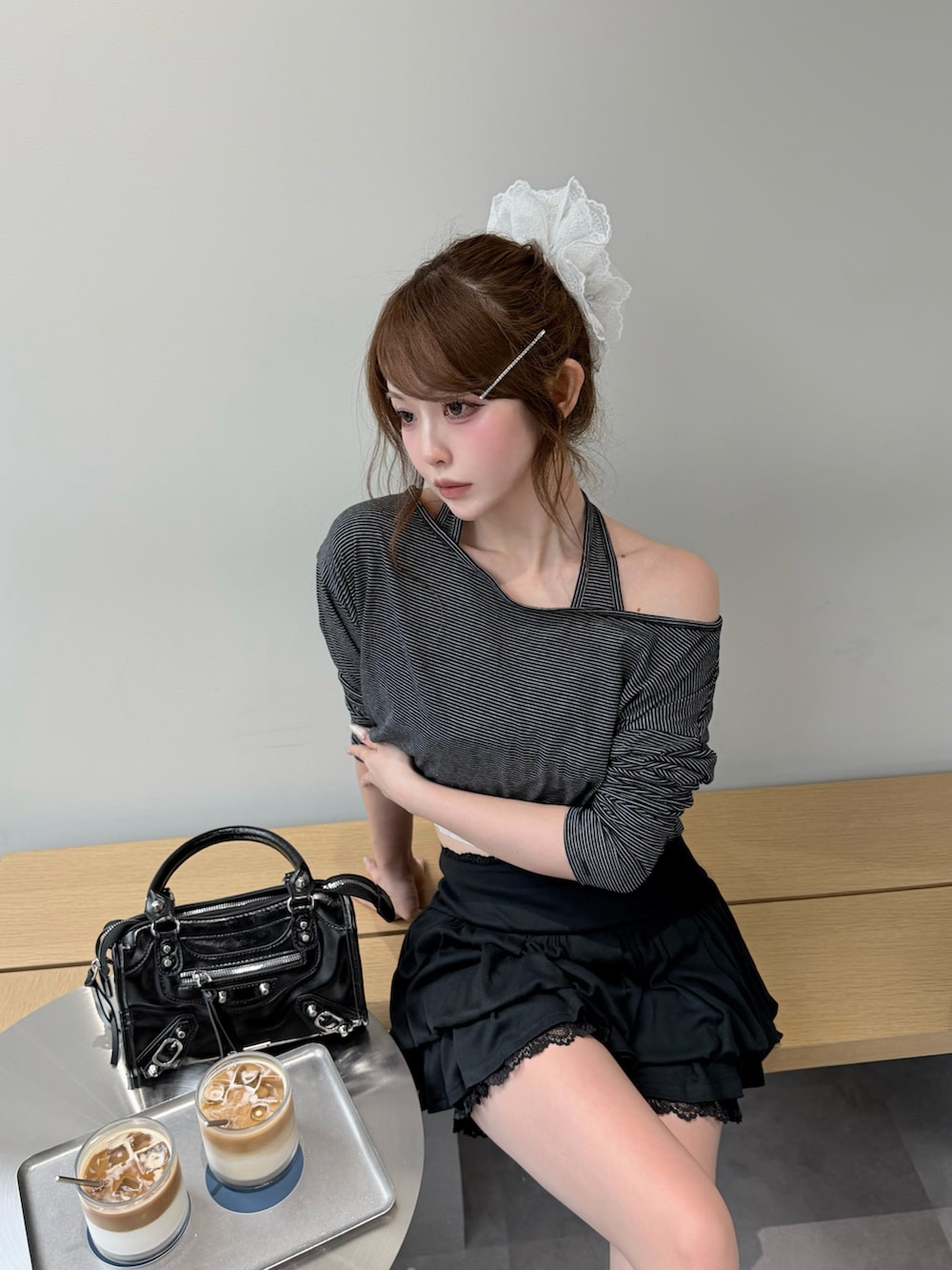 ブラック系のスカート、ブラック系のブーツ、ブラック系のショルダーバッグを着用したレディースの春コーディネートの2枚目の写真