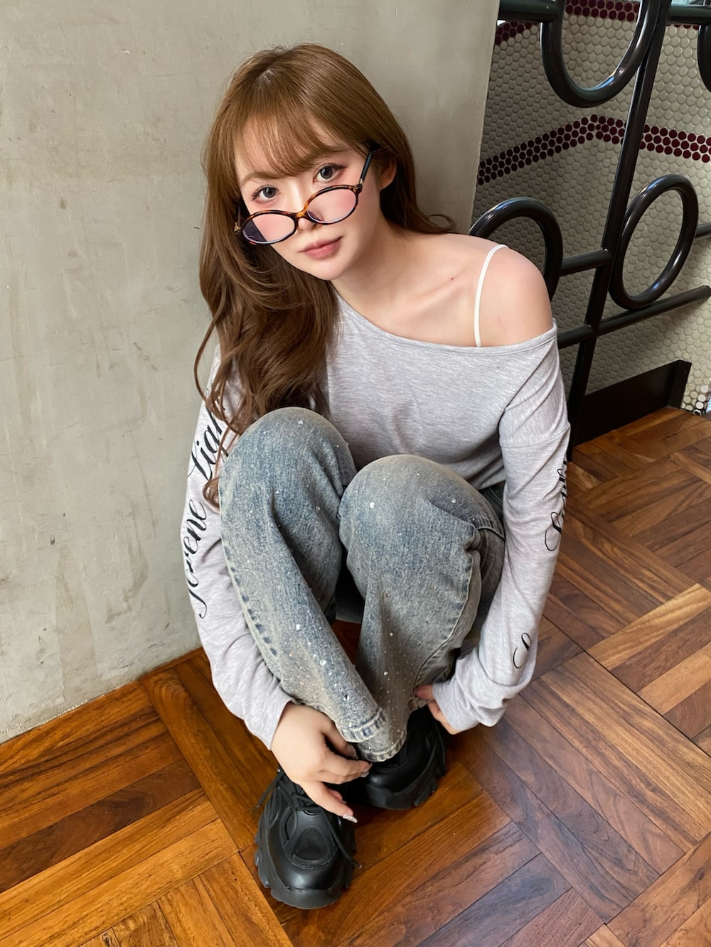 ブルー系のデニムパンツ、ブラック系のスニーカー、グレー系のTシャツ/カットソーを着用したレディースの春コーディネートの2枚目の写真