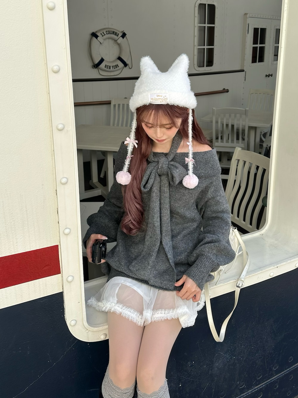 グレー系のニット/セーター、ブラック系のブーツ、ホワイト系のジャケット/アウターを着用したレディースの冬コーディネートの4枚目の写真