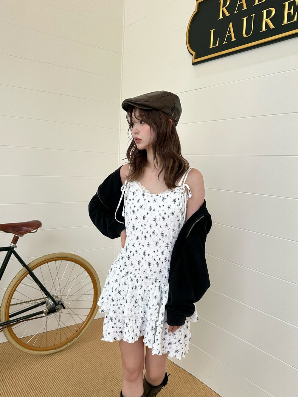 ホワイト系のワンピース、ブラック系のパーカー、ブラック系のブーツを着用したレディースの春コーディネートの2枚目の写真