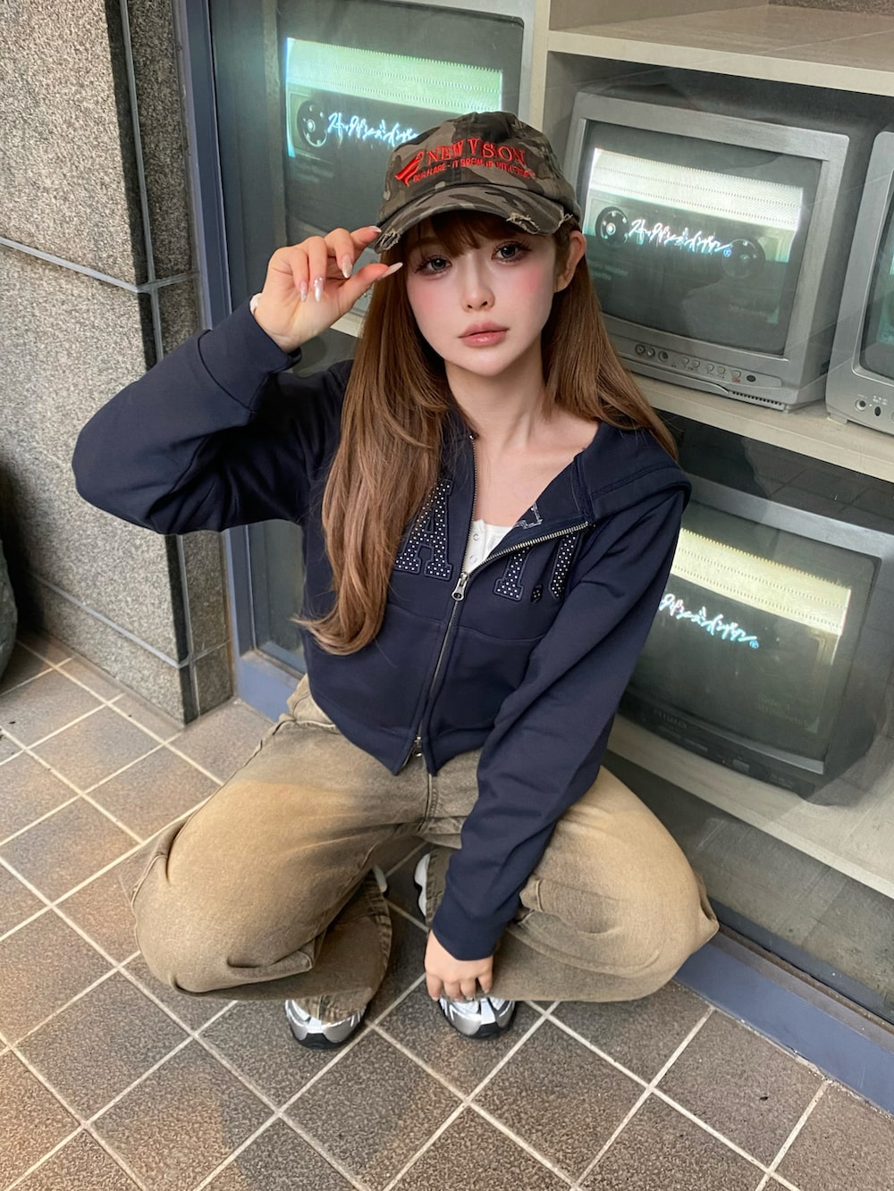 ブルー系のパーカー、ベージュ系のデニムパンツ、シルバー系のスニーカーを着用したレディースの春コーディネートの2枚目の写真