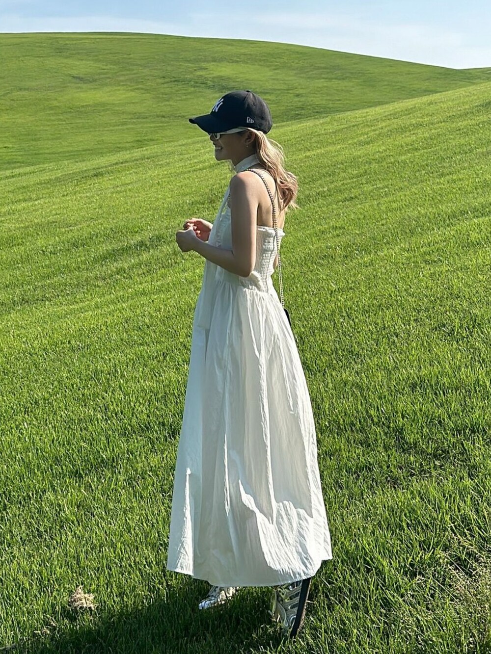ホワイト系のワンピース、シルバー系のスニーカーを着用したレディースの夏コーディネートの3枚目の写真