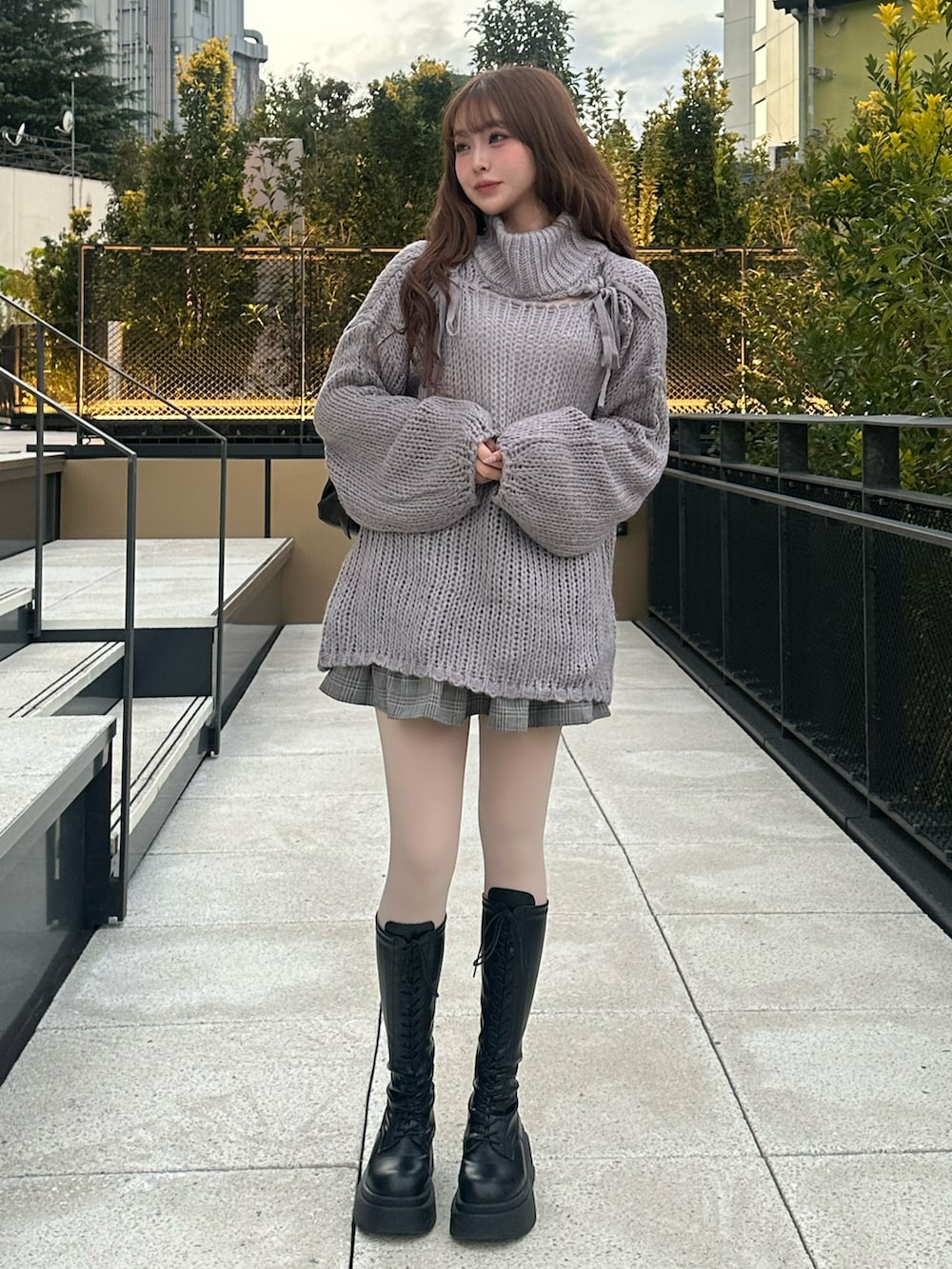 グレー系のワンピース/ドレス、グレー系のジャケット/アウター、ブラック系のブーツを着用したレディースの冬コーディネートの2枚目の写真