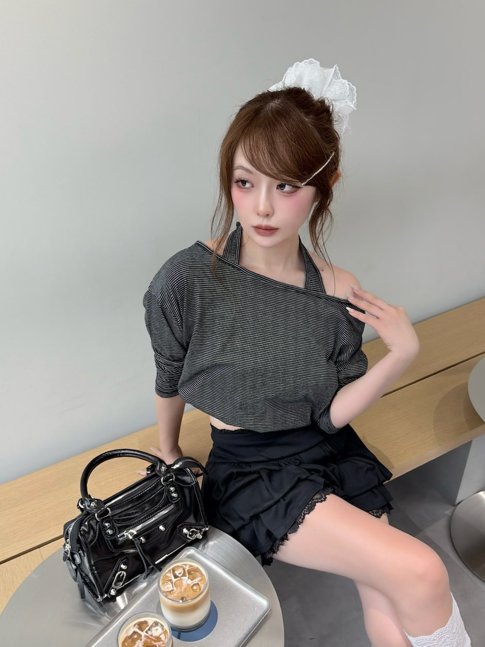 ブラック系のスカート、ブラック系のブーツ、ブラック系のショルダーバッグを着用したレディースの春コーディネートの3枚目の写真
