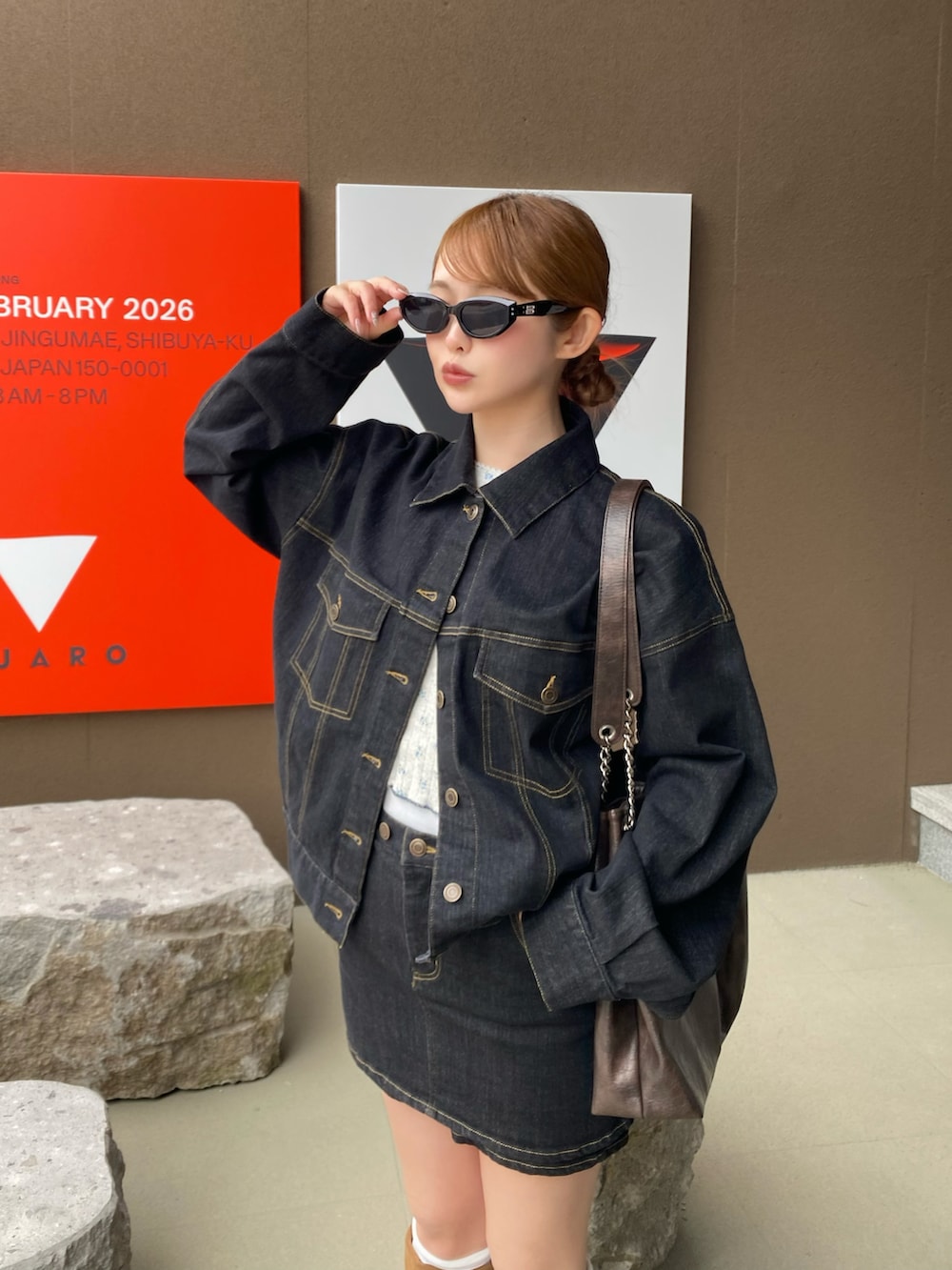 ブラック系のデニムジャケット、ブルー系のスカート、ベージュ系のシューズを着用したレディースの冬コーディネートの3枚目の写真