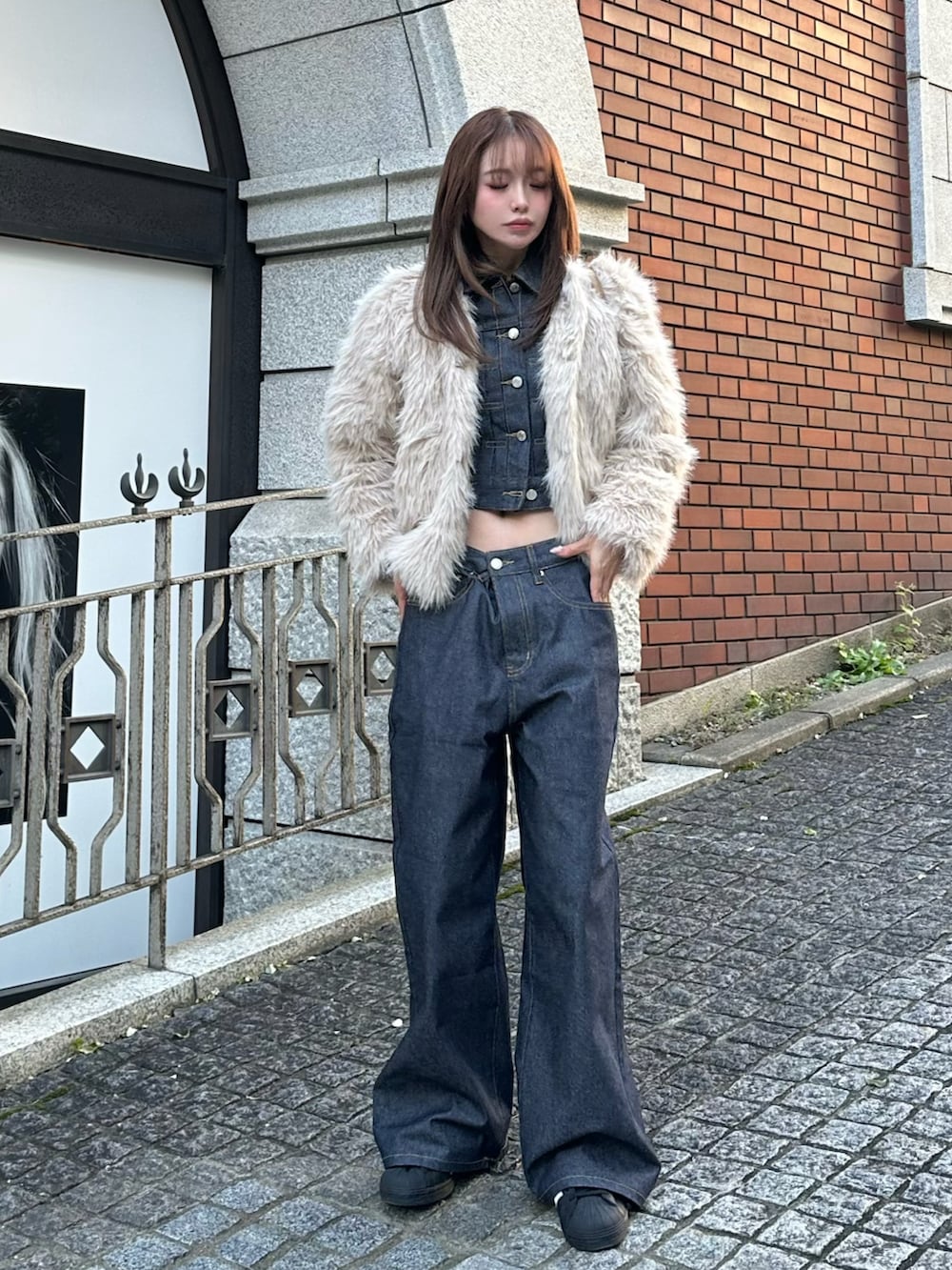 ブラック系のTシャツ/カットソー、ブラウン系のバッグ、ブルー系のデニムパンツを着用したレディースの冬コーディネートの2枚目の写真