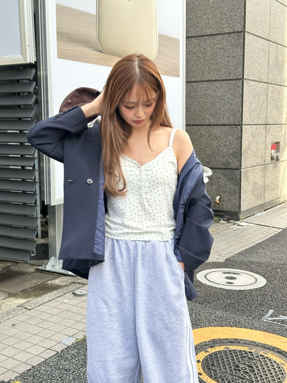 グレー系のスウェットパンツ、ホワイト系のスニーカー、ホワイト系のキャミソールを着用したレディースの春コーディネートの2枚目の写真