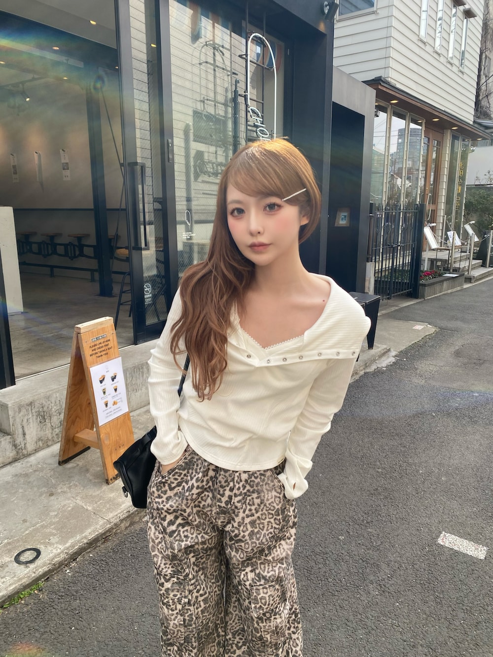 ホワイト系のTシャツ/カットソー、ブラック系のショルダーバッグ、ホワイト系のカーゴパンツを着用したレディースの冬コーディネートの2枚目の写真