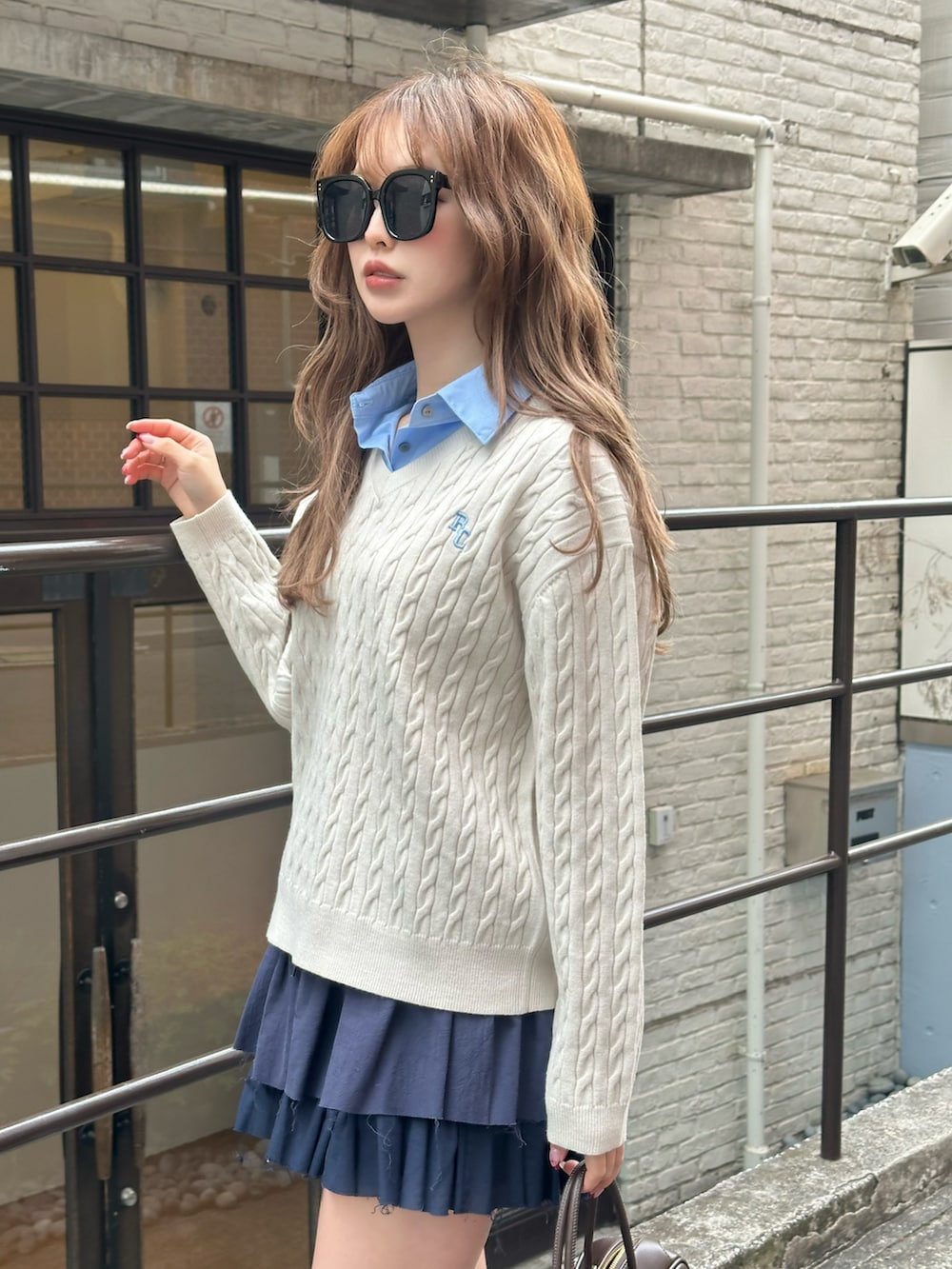 ホワイト系のニット/セーター、ブラウン系のその他シューズ、ブラウン系のボストンバッグを着用したレディースの冬コーディネートの4枚目の写真