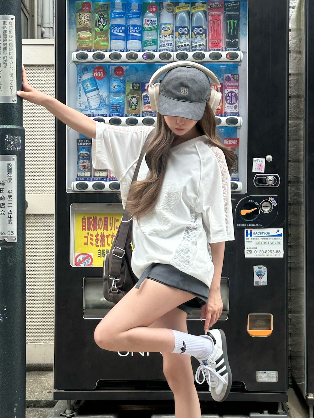 ホワイト系のTシャツ/カットソー、ホワイト系のスニーカー、ブラウン系のショルダーバッグを着用したレディースの春コーディネートの2枚目の写真