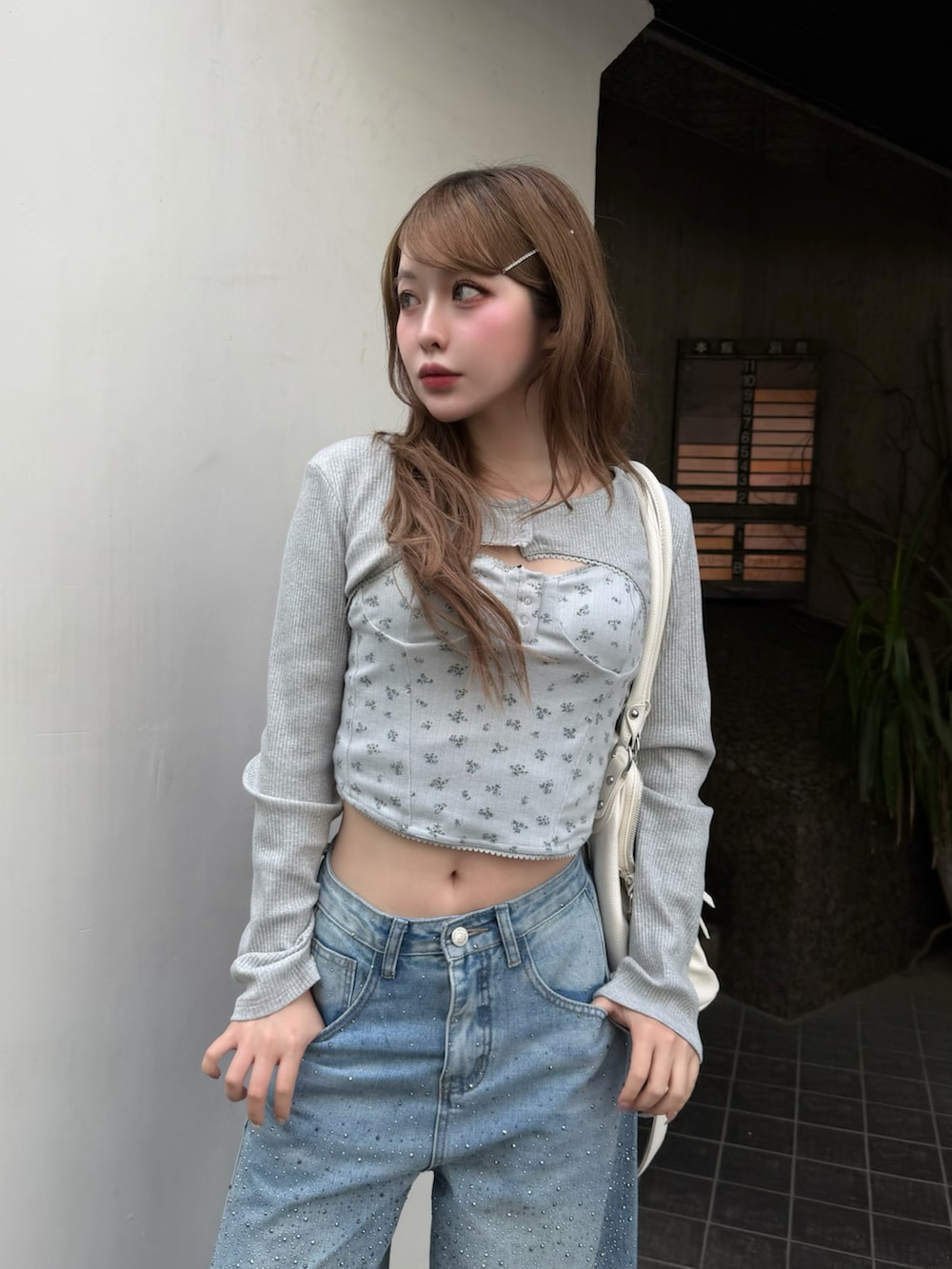 ブルー系のデニムパンツ、グレー系のTシャツ/カットソー、ブラック系のショルダーバッグを着用したレディースの春コーディネートの2枚目の写真