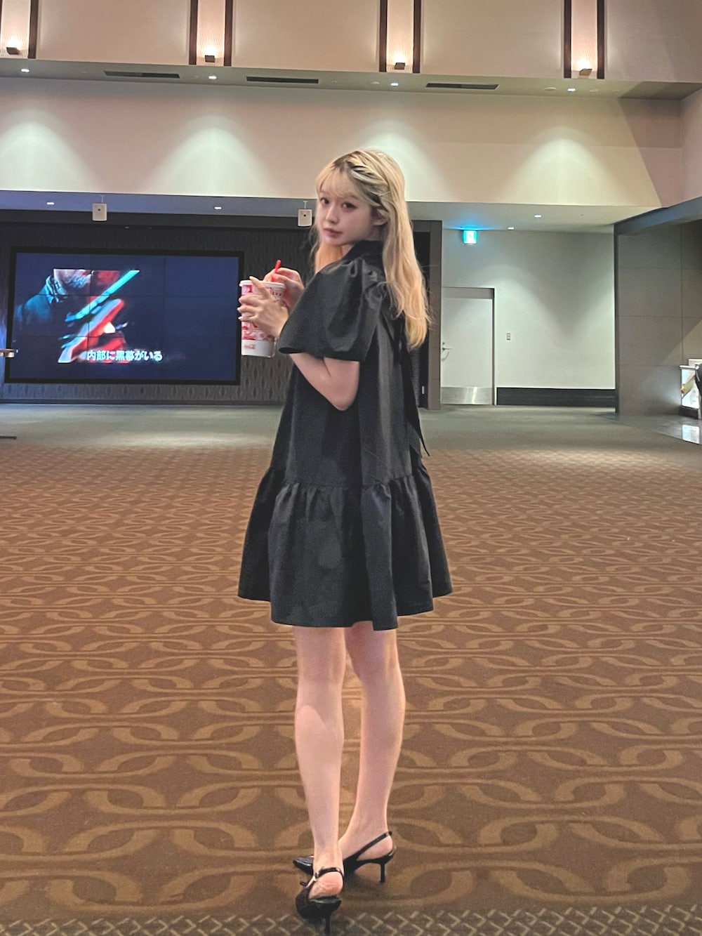 ブラック系のシャツワンピースを着用したレディースの夏コーディネートの2枚目の写真