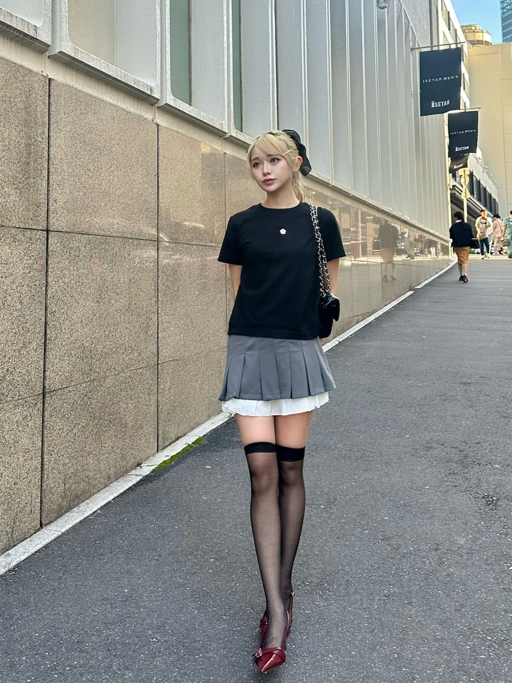 グレー系のスカート、レッド系のシューズ、ブラック系のTシャツ/カットソーを着用したレディースの夏コーディネートの4枚目の写真