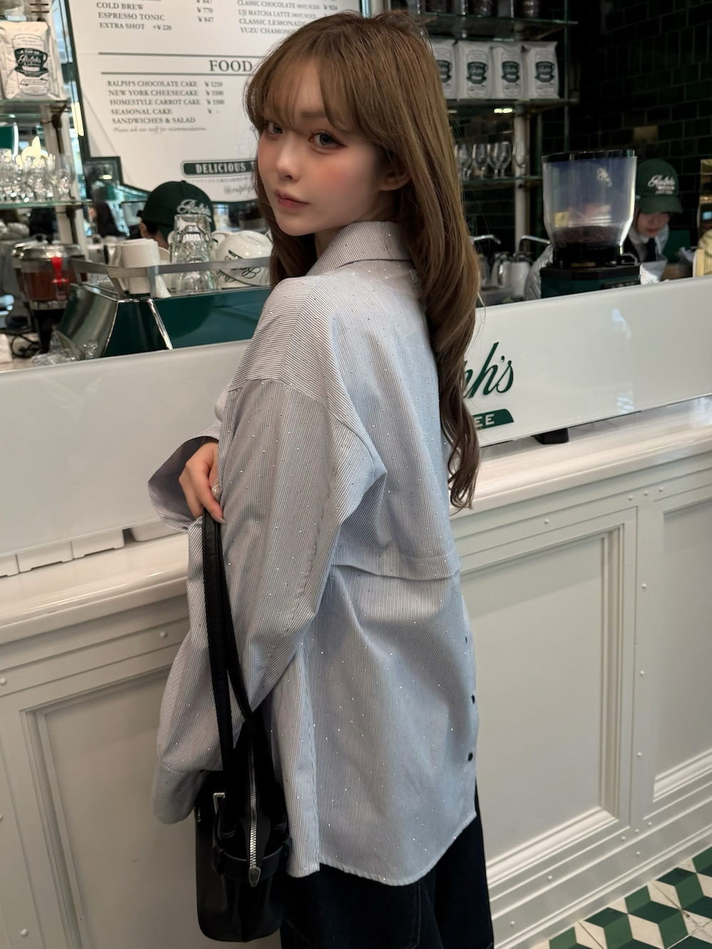 ブルー系のデニムパンツ、ブルー系のシャツ/ブラウス、ブラック系のショルダーバッグを着用したレディースの春コーディネートの3枚目の写真