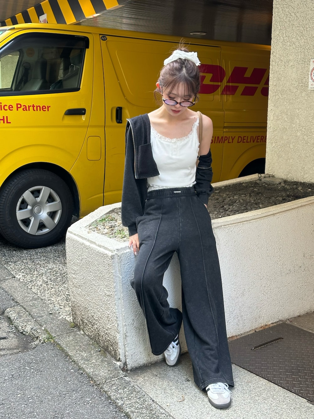 ブラック系のスウェットパンツ、ブラック系のパーカー、ブラウン系のバッグを着用したレディースの春コーディネートの2枚目の写真
